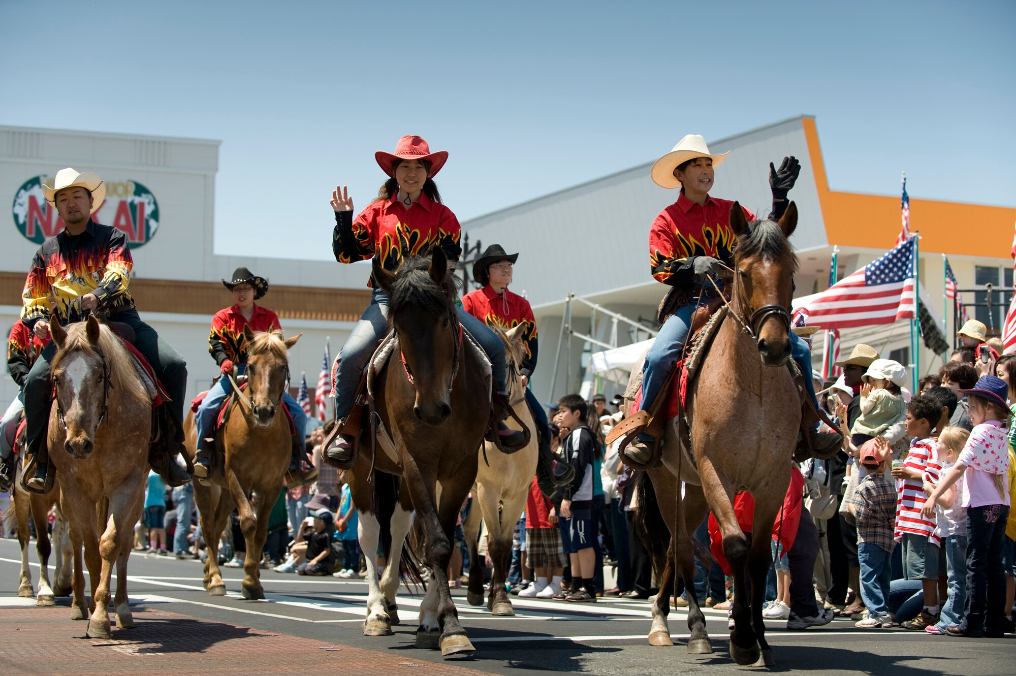 MISAWA CITY, Japan -- The Towada Horseback Riding Club waves to the crowd during the American Day Parade, June 6. The riding club gave horseback rides to children after the parade, enhancing the American Day theme of "Wild Wild West." (U.S. Air Force photo/Staff Sgt. Samuel Morse)