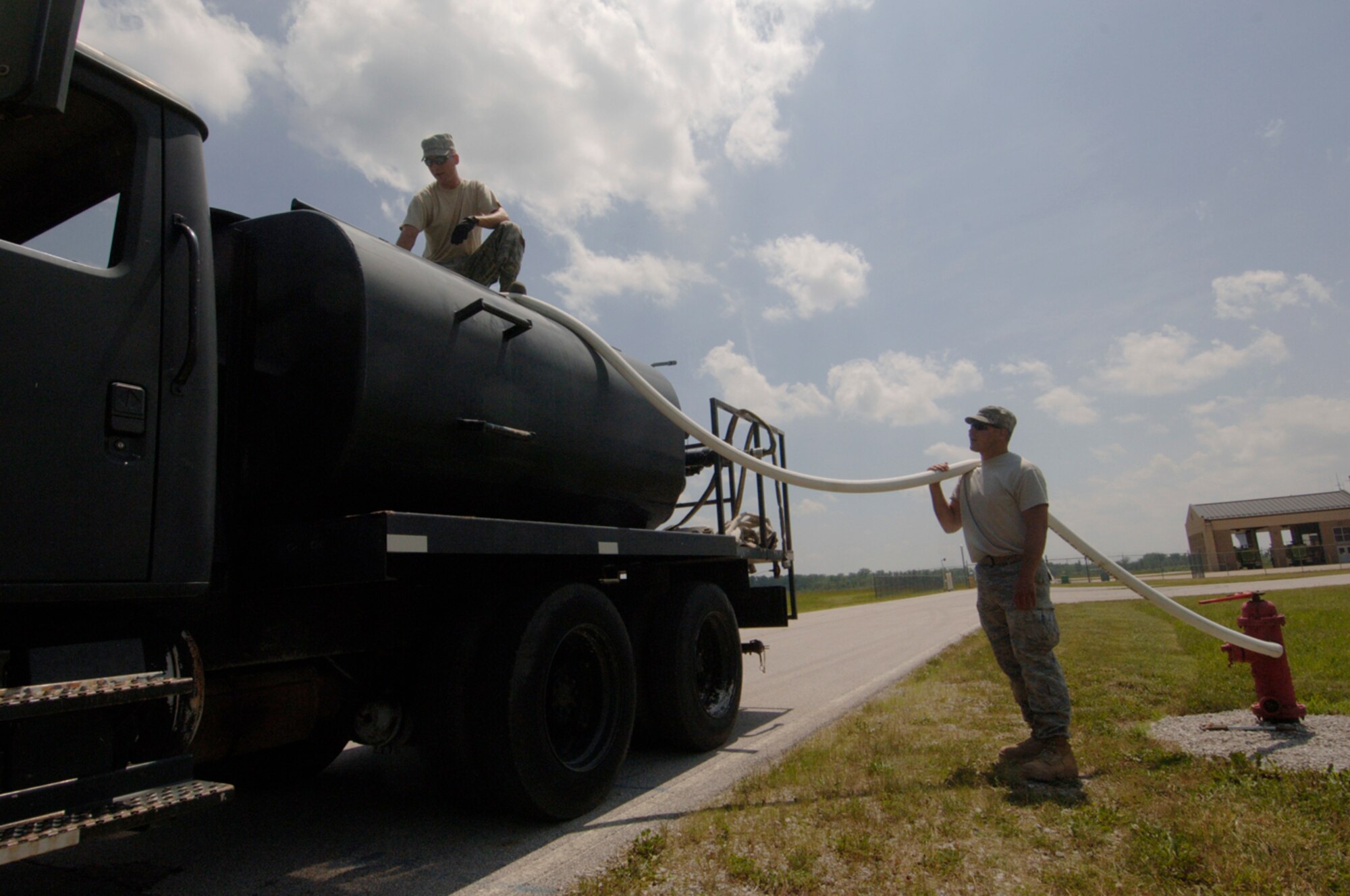 Senior Airman Aaron Reedy and Staff Sgt. Kyle Troxell, 375th Civil Engineer Squadron Operations Flight, fill up the water truck before pouring it onto a 3.2 mile course of muck, mud and hay obstacles.  More than 1,000 runners competed in the second annual USO Mud Run at Mid-America Airport June 5, 2010. The 375th CES helped construct the course and ensured its "mudworthiness" and numerous base volunteers assisted with the event.  The Airmen said they volunteered to help because it was one small way to repay the USO for all the work they do on behalf of servicemembers everywhere. (Photo by Karen Petitt/375th AMW/PA)
