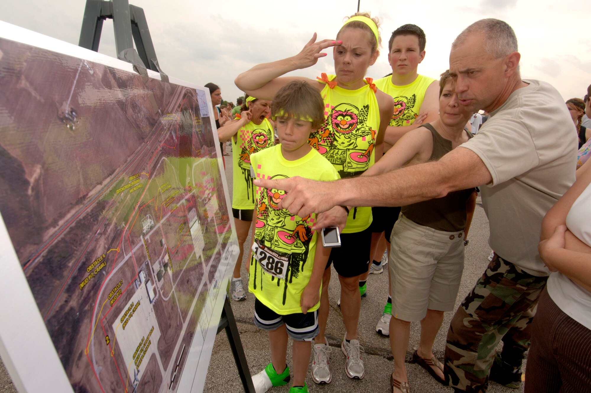 Runners check out the course map that will lead them through 3.2 miles of muck, mud and hay obstacles.  More than 1,000 runners competed in the second annual USO Mud Run at Mid-America Airport June 5, 2010. Members of Scott's 375th Civil Engineering Squadron helped construct the course and ensured its "mudworthiness" and numerous base volunteers assisted with the event. (Photo by Karen Petitt/375th AMW/PA)