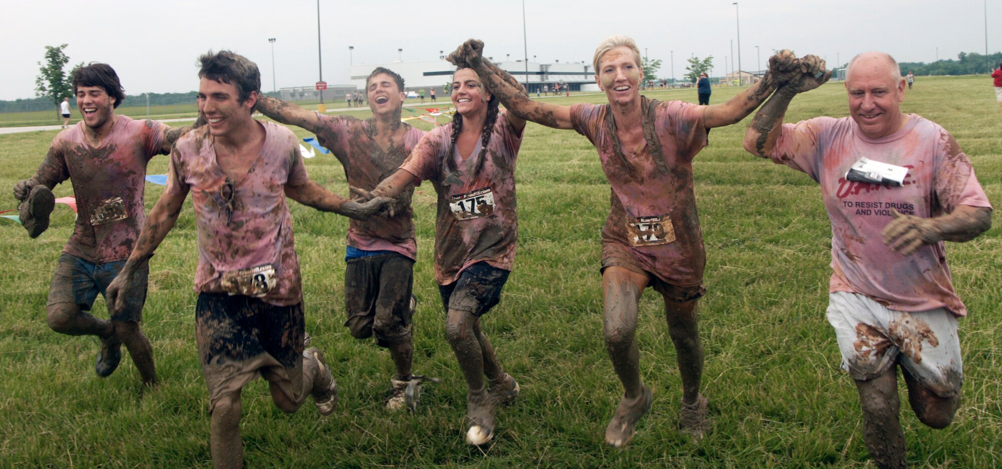A co-ed team from St. Louis crosses the finish line after trasping through a 3.2 mile course of muck, mud and hay.  More than 1,000 runners competed in the second annual USO Mud Run at Mid-America Airport June 5, 2010. Members of Scott's 375th Civil Engineering Squadron helped construct the course and ensured its "mudworthiness" and numerous base volunteers assisted with the event. (Photo by Karen Petitt/375th AMW/PA)