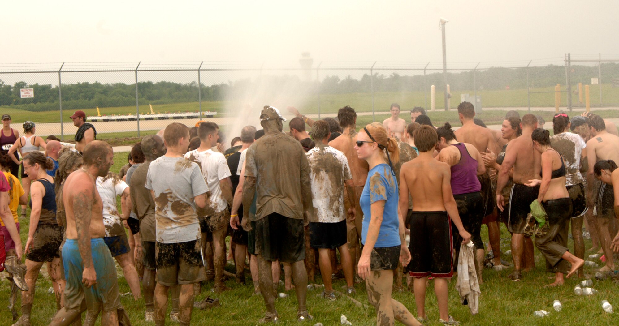Runners wash off after running a 3.2 mile course through muck, mud and hay.  More than 1,000 runners competed in the second annual USO Mud Run at Mid-America Airport June 5, 2010. Members of Scott's 375th Civil Engineering Squadron helped construct the course and ensured its "mudworthiness" and numerous base volunteers assisted with the event. (Photo by Karen Petitt/375th AMW/PA)