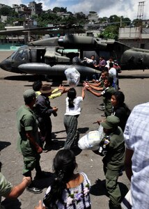 Guatemalan military and citizens of Santiago Atitlan, Guatemala offload disaster relief supplies from a Joint Task Force-Bravo UH-60 Blackhawk June 6. Joint Task Force-Bravo’s helicopters have transported approximately 152,000 pounds of relief supplies since June 2 to 14 Guatemalan communities in need. (U.S. Air Force photo by Staff Sgt. Bryan Franks)