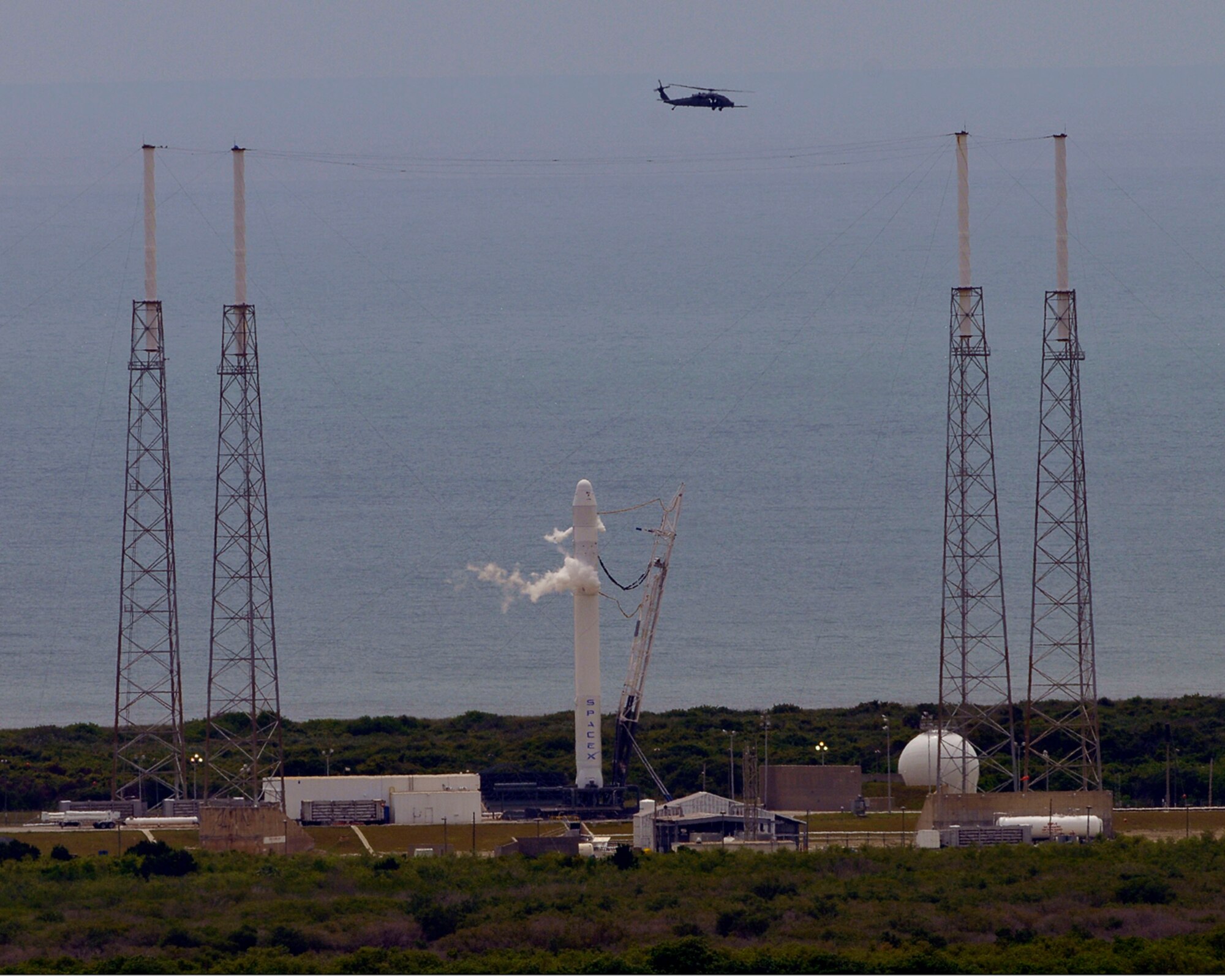 CAPE CANAVERAL AIR FORCE STATION, Fla.- An HH-60G Pave Hawk helicopter from the 920th Rescue Wing, Patrick Air Force Base, Fla., patrols the areas surrounding the inagural launch of the SPACEX Flacon 9 rocket. The rescue reservists from the 920th RQW are on hand during every rocket and shuttle launch to ensure the safety of the public. The wing helicopter crews are responsible for a 10-mile wide by 70-mile long strip of the Atlantic Ocean. (Courtesy photo)