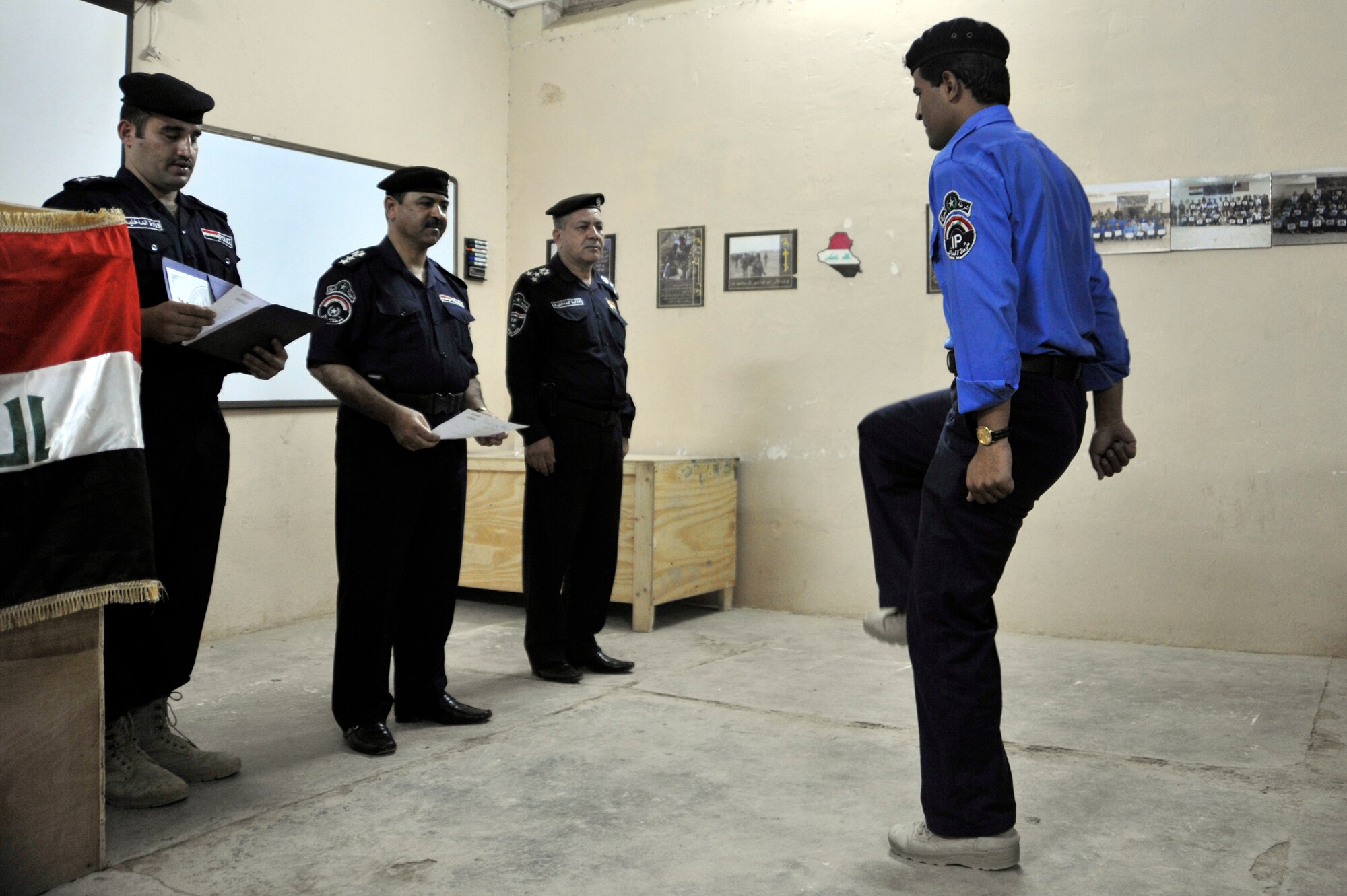 An Iraqi Police graduate from the Taji Law Enforcement Academy marches up to receive his certificate June 3, 2010, at Camp Taji, Iraq. The academy students were instructed on more advanced subjects such as, evidence gathering, crime scene sketching finger printing and securing a building. (U.S. Air Force photo by Senior Airman Perry Aston) (Released)