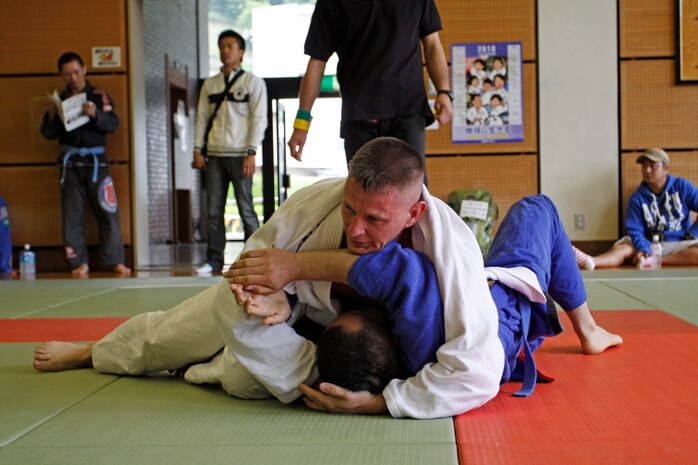 Hugh McClenney, blue-belt competitor, keeps a dominant position as he holds down his opponent during the 4th annual Chugoku-Shikoku Jujitsu Championship at the Hiroshima Minami Ward Sports Center. June 6. McClenney took first place in his weight class and fourth place in the absolute blue-belt tournament during which the winners from each weight class competed overall.