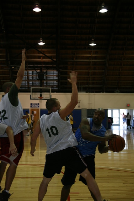 Staff Sgt. Devin A. Smith, administration chief with Marine Tactical Electronic Warfare Squadron 3, looks for an open teammate during a game in the Semper Fit Athletics three-on-three basketball tournament at the Marine Dome, June 7. The Marine Dome reopened June 3 after undergoing extensive renovations that began March 2009.