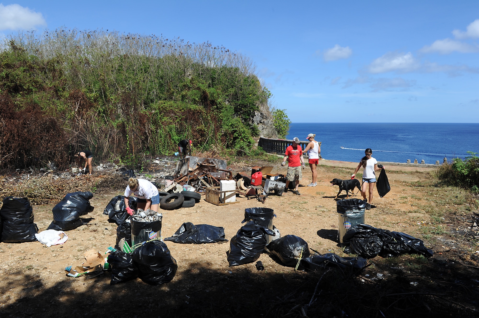 ANDERSEN AIR FORCE BASE, Guam - Junior Air Force officers from Andersen Air Force Base's Company Grade Officer Council clean up trash at a local cliffline. All told, the 13 officers and several local residents cleaned up 890 pounds of scrap metal, 315 pounds of glass, 15 bags of plastic bottles, 55 pounds of aluminum cans, and 25 bags of trash. Approximately 75 percent, by weight, of all the materials was able to be recycled locally by the group. The officers plan to return to the site once a month to perform cleanup and preventive maintenance. Anyone interested in participating can contact 2nd Lt. James Elliott at 366-2520. (U.S. Air Force photo by Tech. Sgt. Mike Andriacco)