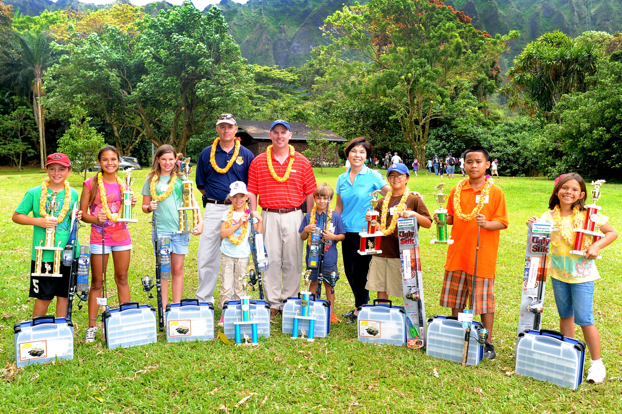 JOINT BASE PERAL HARBOR HICKAM, Hawaii  -- Ryan Strong, 10; Mahinalani Cavalieri, 12; Kristina Poe, 12, Madilyn Wilson, 5; Benjamin Rolfe, 5; Tyler Menzel, 9; Kelwen Lee Chung Jr., 11; and Abigael McCain, 11 took home trophies for the most fish and biggest fish in their categories at the Keiki Fishing Tournament, hosted by Friends of Hickam, June 2 at the Ho`omaluhia Botanical Gardens. Keiki, the Hawaiian word for children, caught a tournament record 732 fish. This is the 11th straight year the Friends of Hickam has hosted the event for more than 200 children every year. Chief Master Sgt. Craig Recker, 15th Wing command chief master sergeant, Col. Sam Barrett, 15th WG commander, and Gwen Omori, Friends of Hickam president, pose with the children. (U.S. Air Force photo/SSgt. Mike Meares)