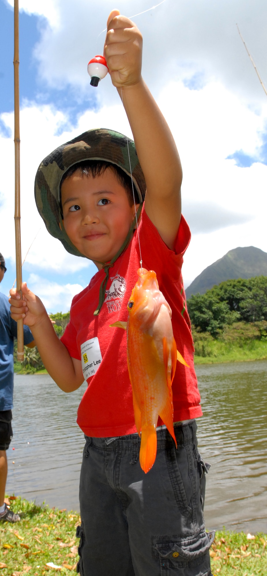 JOINT BASE PERAL HARBOR HICKAM, Hawaii -- Christopher Lee, 6, poses with his catch ???during the Friends of Hickam Keiki Fishing Tournament June 2 at the Ho`omaluhia Botanical Gardens. Keiki, the Hawaiian word for children, caught 732 fish at the fishing tournament. This is the 11th straight year the Friends of Hickam has hosted the event for more than 200 children. (U.S. Air Force photo/SSgt. Mike Meares)