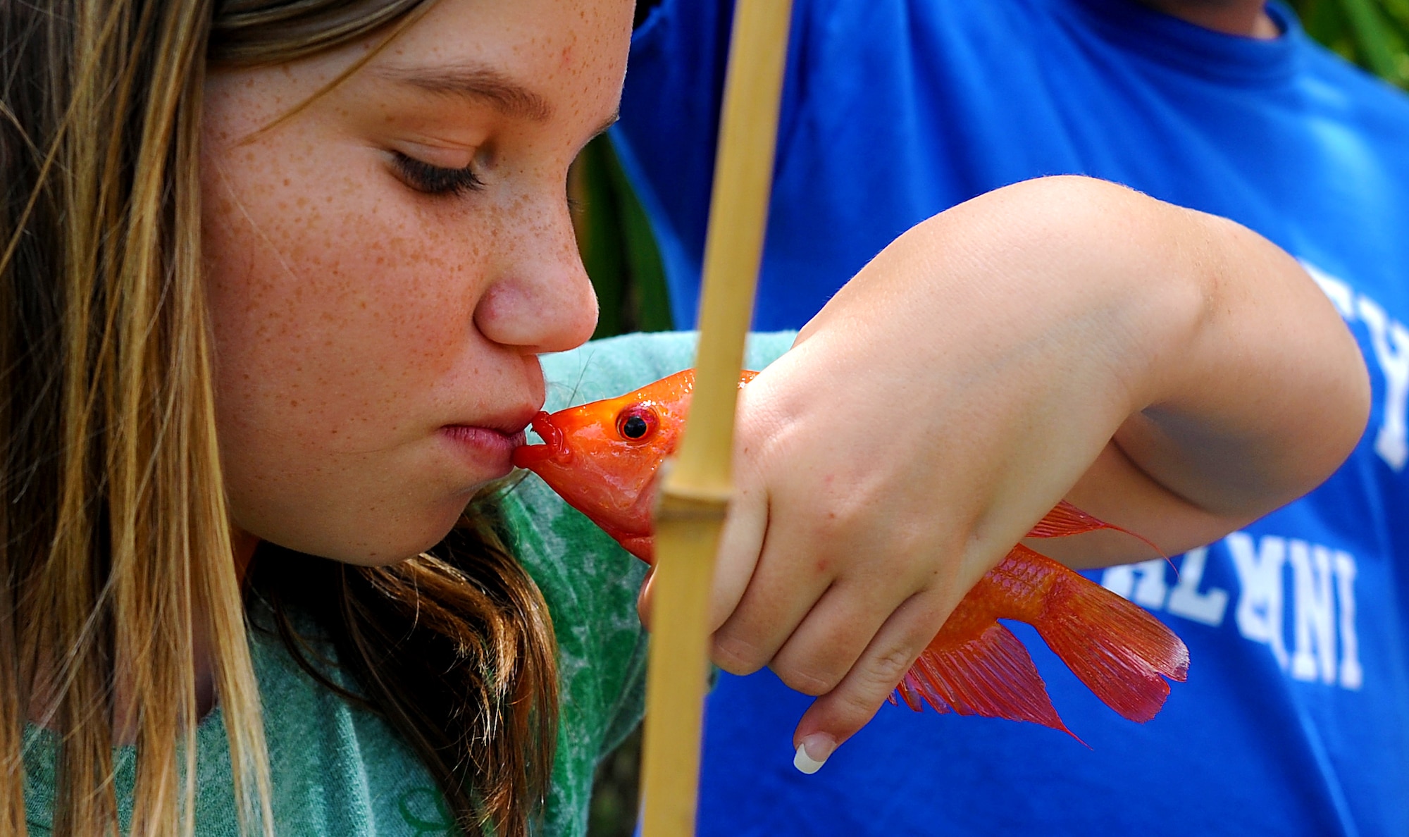JOINT BASE PERAL HARBOR HICKAM, Hawaii  -- Kristina Poe, 12, gives one of the 27 fish she caught a smooch before she releases it during the Keiki Fishing Tournament, hosted by Friends of Hickam, June 2 at the Ho`omaluhia Botanical Gardens. Keiki, the Hawaiian word for children, caught a tournament record 732 fish. This is the 11th straight year the Friends of Hickam has hosted the event for more than 200 children every year. (U.S. Air Force photo/SSgt. Mike Meares)