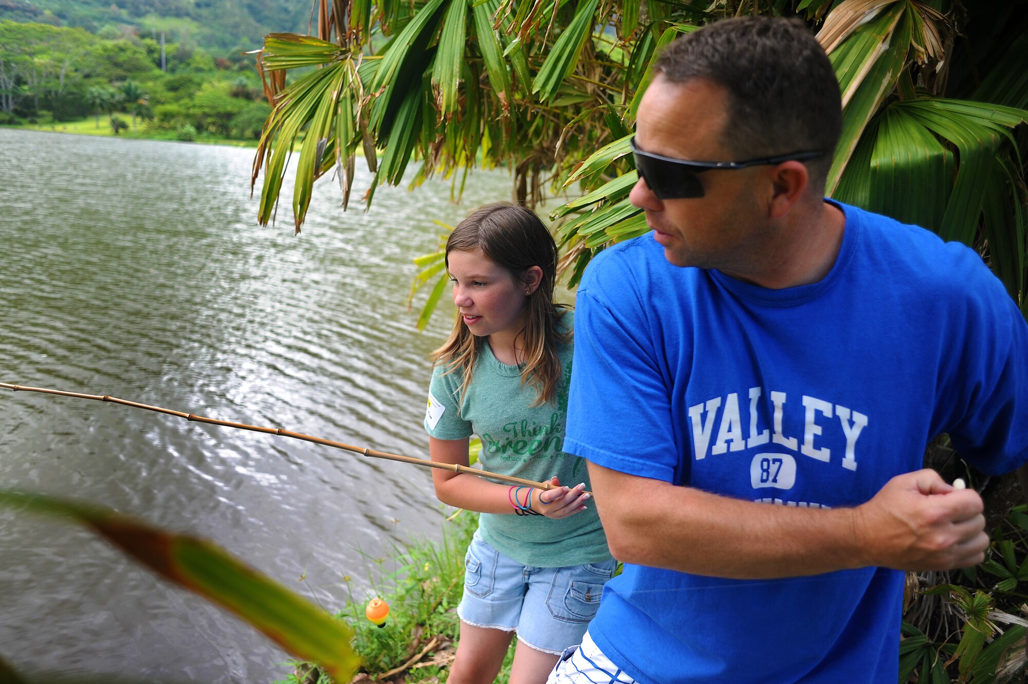 JOINT BASE PERAL HARBOR HICKAM, Hawaii  -- Kristina Poe, 12, and her dad Master Sgt. Mike Poe, Pacific Command, works as a team during the Keiki Fishing Tournament, hosted by Friends of Hickam, June 2 at the Ho`omaluhia Botanical Gardens. Keiki, the Hawaiian word for children, caught a tournament record 732 fish. This is the 11th straight year the Friends of Hickam has hosted the event for more than 200 children every year. The Poe's caught the tournament?s second most fish at 27, being overtaken by a single catch. Kristina broke the previous record for girls set last year at 21. (U.S. Air Force photo/SSgt. Mike Meares)