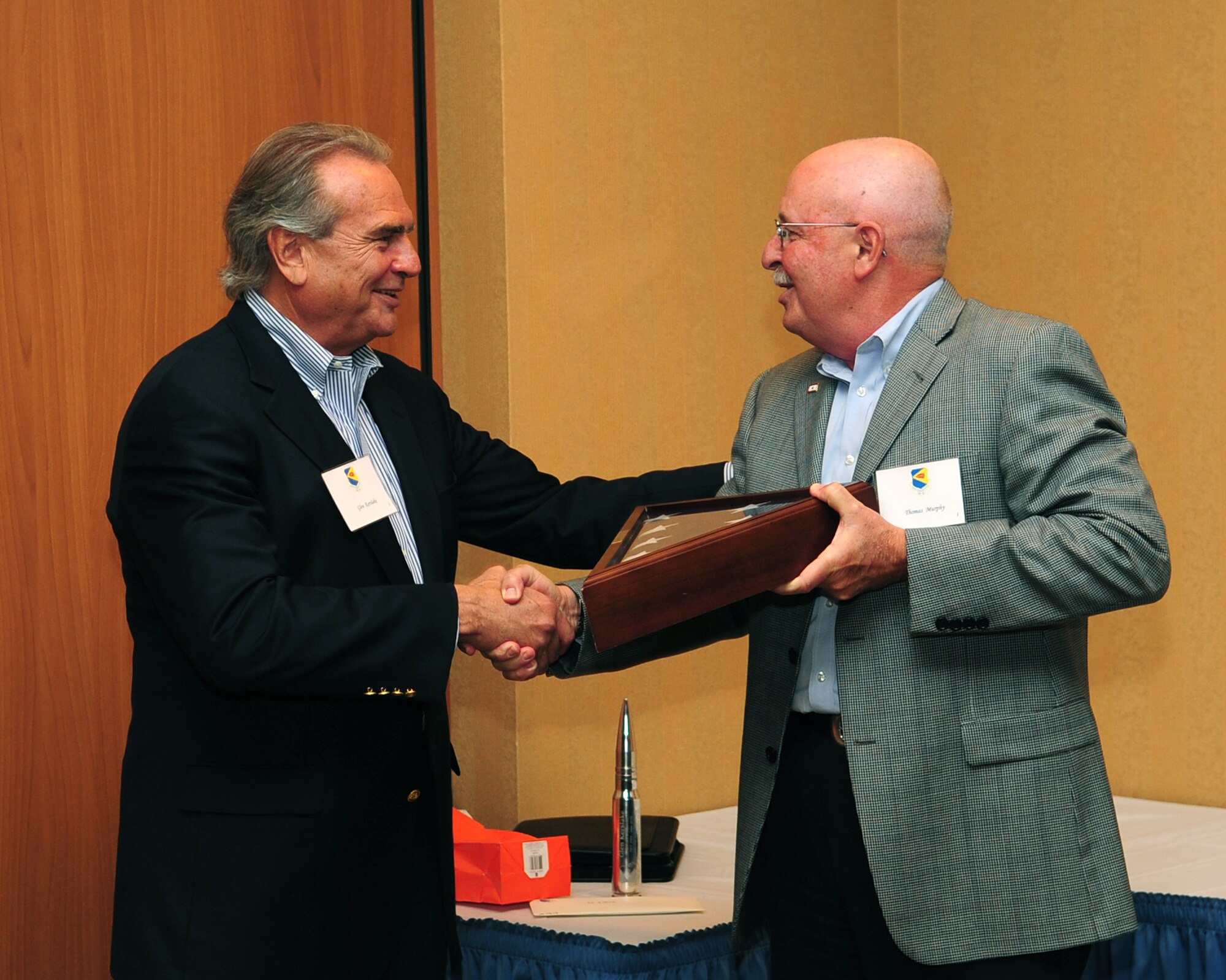 Tom Murphy (right), new DM-50 president, presents a parting gift to preceding president Glen Kerslake at the Mirage Club here June 3. Formed in 1986, the DM-50 is a non-profit, volunteer service organization, which functions as an advocate for the base and aims to bridge relationships between the base and the commercial, political, educational, and social leadership of Tucson and Pima County. (U.S. Air Force photo/Airman 1st Class Jerilyn Quintanilla)