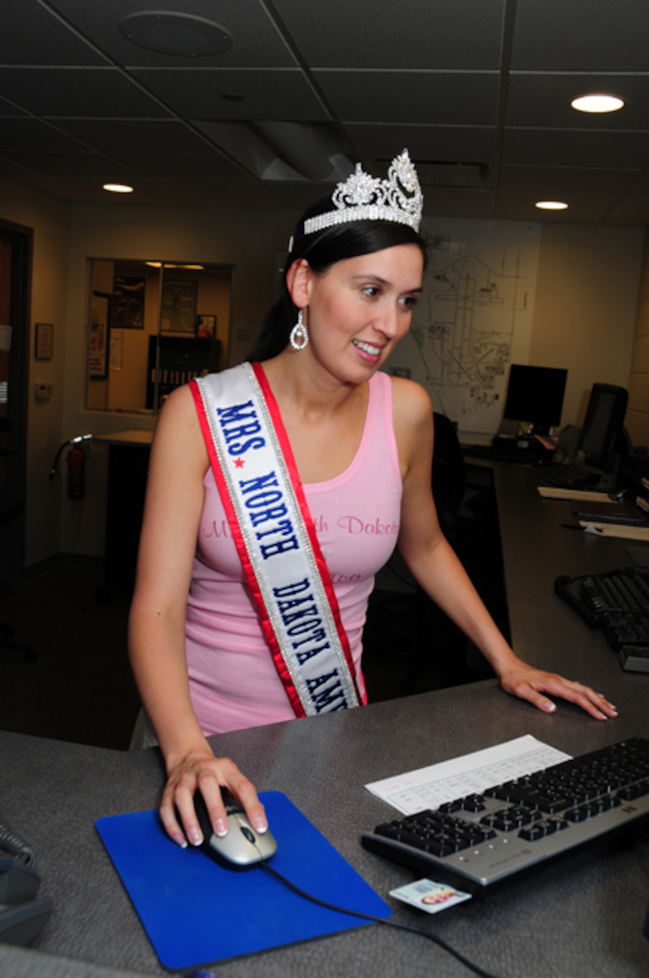 Newly crowned Mrs. North Dakota America, Tech. Sgt. Tera Miller, of the 119th Operations Support Squadron, visits her work area June 7, at the North Dakota Air National Guard, Fargo, N.D.  Miller was selected 2010 Mrs. North Dakota America at the Grand Masonic Lodge, June 6, in Fargo.  One of Millers competitors for the crown was fellow Guard member SGT. Jill Johnson, with the North Dakota Army National Guard.  Miller will advance to the National Mrs. America pageant in Tuscan, Ariz., in September.  Miller, along with her twin sister Tech. Sgt. Lisa Narum joined the North Dakota Air National Guard in 2001. (DoD photo by Senior Master Sgt. David H. Lipp) 

