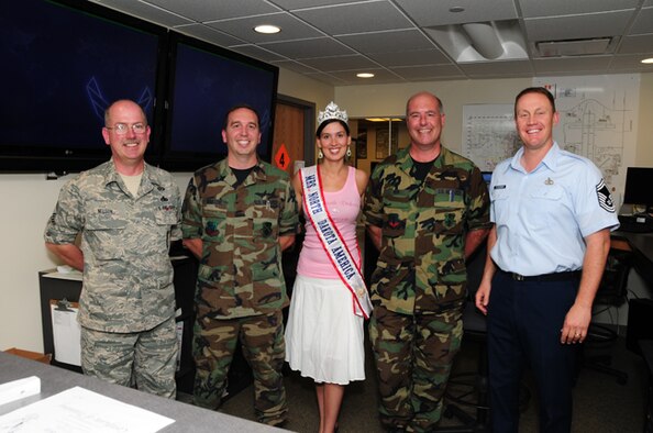 Newly crowned Mrs. North Dakota America, Tech. Sgt. Tera Miller, of the 119th Operations Support Squadron, visits her work area June 7, at the North Dakota Air National Guard, Fargo, N.D.  She is surrounded by her coworkers from left to right, Senior Master Sgt. Kevin Nelson, Tech. Sgt. Christopher Schatzke, Master Sgt. Brian Rook, and Senior Master Sgt. Scott Flickinger.  Miller was selected 2010 Mrs. North Dakota America at the Grand Masonic Lodge, June 6, in Fargo.  One of Millers competitors for the crown was fellow Guard member SGT. Jill Johnson, with the North Dakota Army National Guard.  Miller will advance to the national Mrs. America pageant in Tuscan, Ariz., in September. Miller, along with her twin sister Tech. Sgt. Lisa Narum joined the North Dakota Air National Guard in 2001. (DoD photo by Senior Master Sgt. David H. Lipp) 

