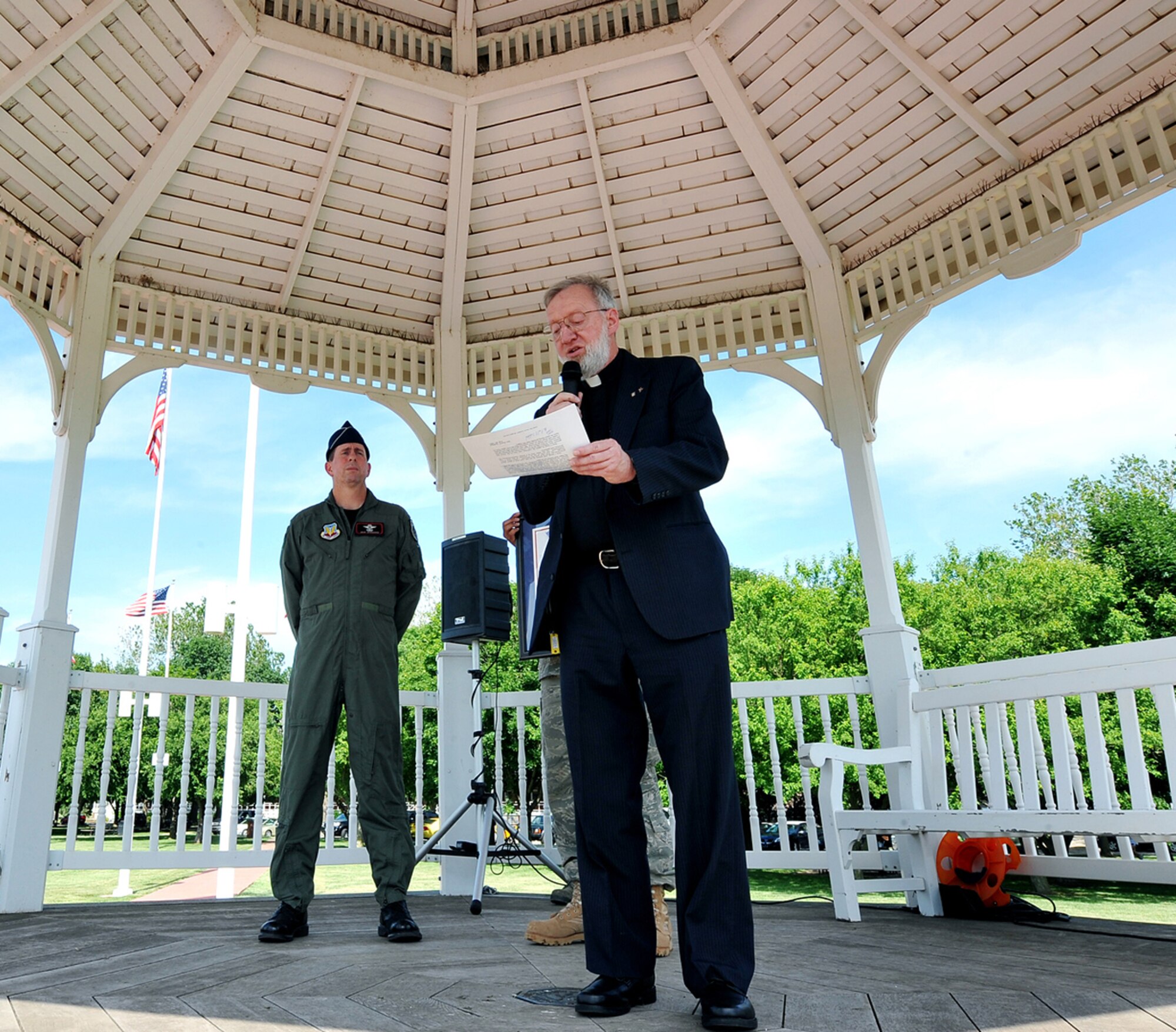 OFFUTT AIR FORCE BASE, Neb. - Brig. Gen. John N.T. Shanahan, 55th Wing commander, listens to parrish Pastor Paul Goddard read "Permanent Duty Station" a poem he wrote to honor servicemembers at the parade grounds here June 3. After reading the poem, Chaplain Goddard presented it to General Shanahan as a way to thank the members of Team Offutt for all they do. U.S. Air Force Photo by Charles Haymond 