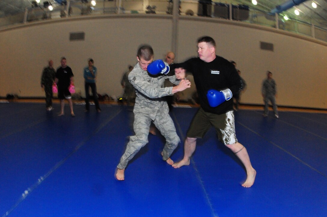 U.S. Military combative training instructor Sgt. Jon Blazek, of the N.D. Army National Guard pre-deployment team, right, throws a punch at Senior Airman Joshua Shoemaker, of the 91st SSPTS, May 13, at the Minot Air Force Base, Minot, N.D.  Blazek is providing a realistic punching attack, as Shoemaker tries to close the distance, avoid the punches and achieve a clinch during the training.  Shoemaker is a student in a combative training course, learning techniques that can help in security forces duties at Minot AFB, and in future deployments.