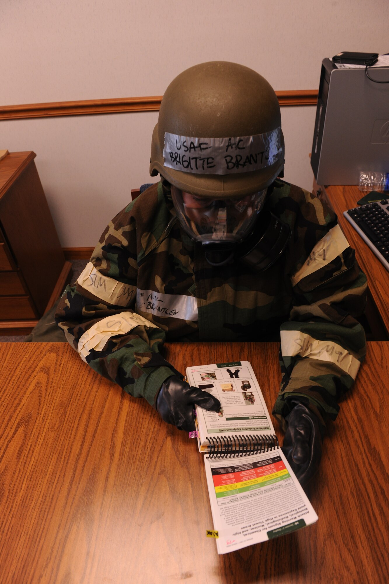 MOODY AIR FORCE BASE, Ga. -- An Airman uses her Airman’s Manual during a Phase II Operational Readiness Exercise here June 4 to reference the section where it differentiates between the alarm levels and the requirements for each. The manual contains a great amount of useful information for Airmen in deployed locations. (U.S.  Air Force photo by Airman 1st Class Joshua Green/RELEASED)