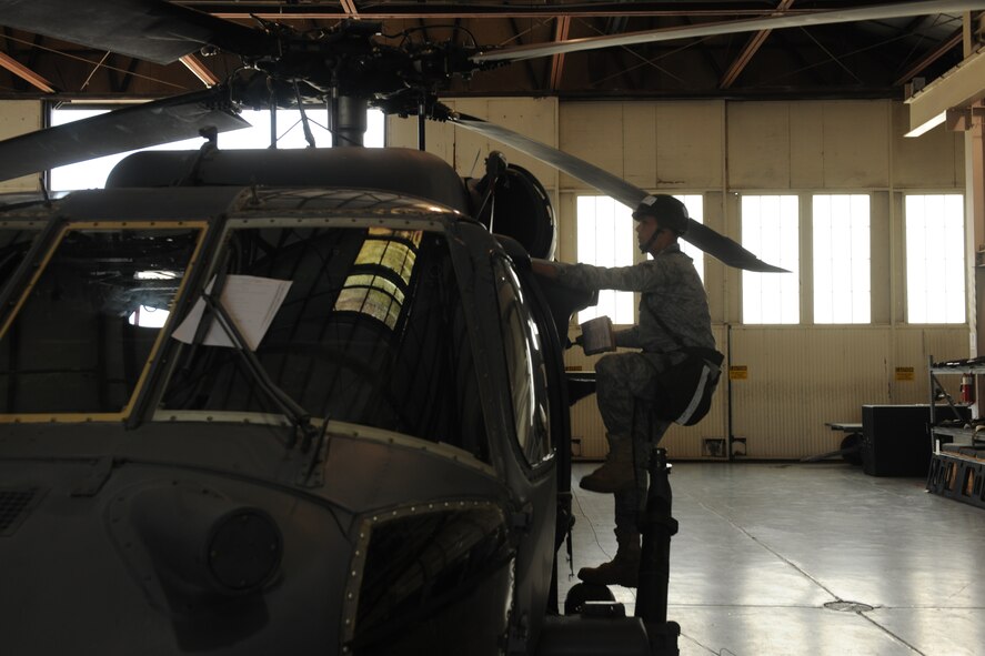 MOODY AIR FORCE BASE, Ga. -- Senior Airman Jason Schwenn, 41st Helicopter Maintenance Unit crew chief, performs an inspection on an HH-60G Pave Hawk during a Phase II Operational Readiness Exercise here June 4. In a deployed location, crew chiefs are one of many career fields responsible for making sure helicopters can remain on flying status so their crews can complete personnel recovery missions. (U.S.  Air Force photo by Airman 1st Class Joshua Green/RELEASED)