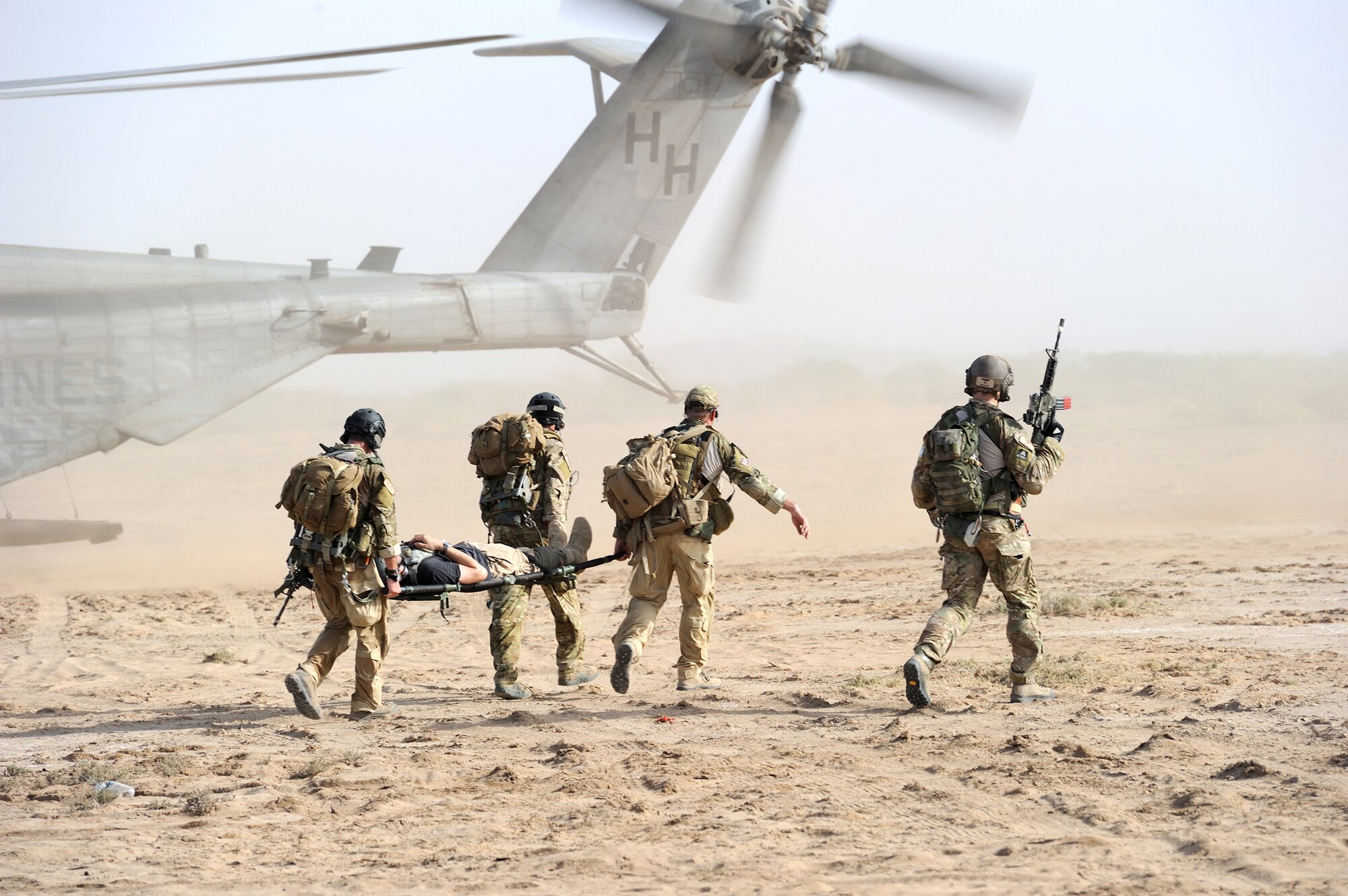 Air Force pararescuemen transport an injured "victim" to a waiting U.S. Marine Corps MH-53 Super Stallion while conducting a combat search and rescue exercise outside of Camp Lemonnier, Djibouti, June 1, 2010.  (U.S. Air Force photo/Master Sgt. Jeremiah Erickson)