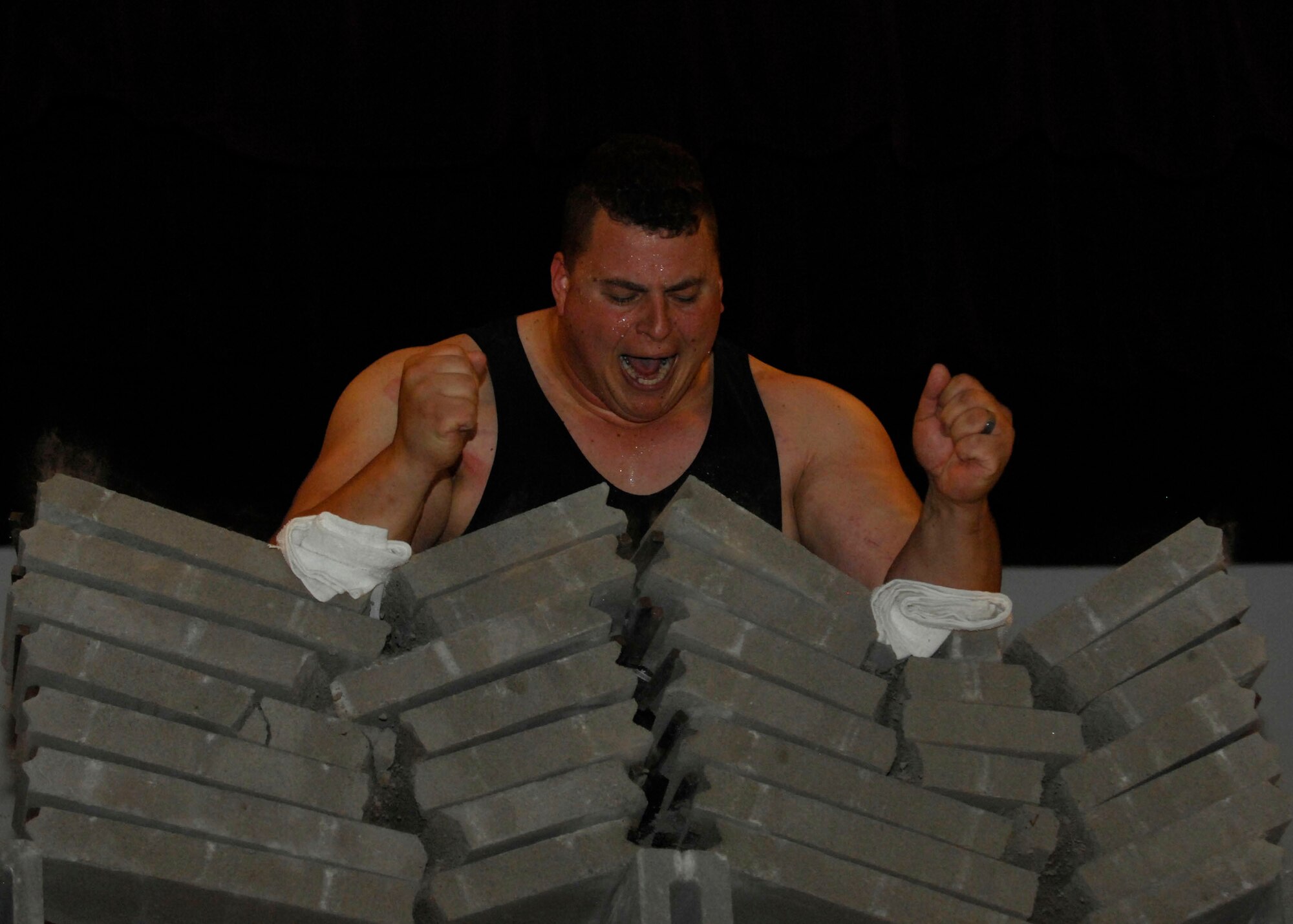 MINOT AIR FORCE BASE, N.D. -- P.J. Hoeper, Strength Team member, breaks two piles of cement blocks at the base theater here June 2. After crushing the bricks, Hoeper gave an inspirational speech about his relationship with God to those in attendance. (U.S. Air Force photo by Senior Airman Ashley N. Avecilla)