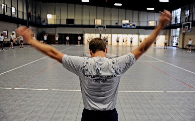 A Battlefield Airman trainee stretches out his shoulders prior to participating in a group cross-