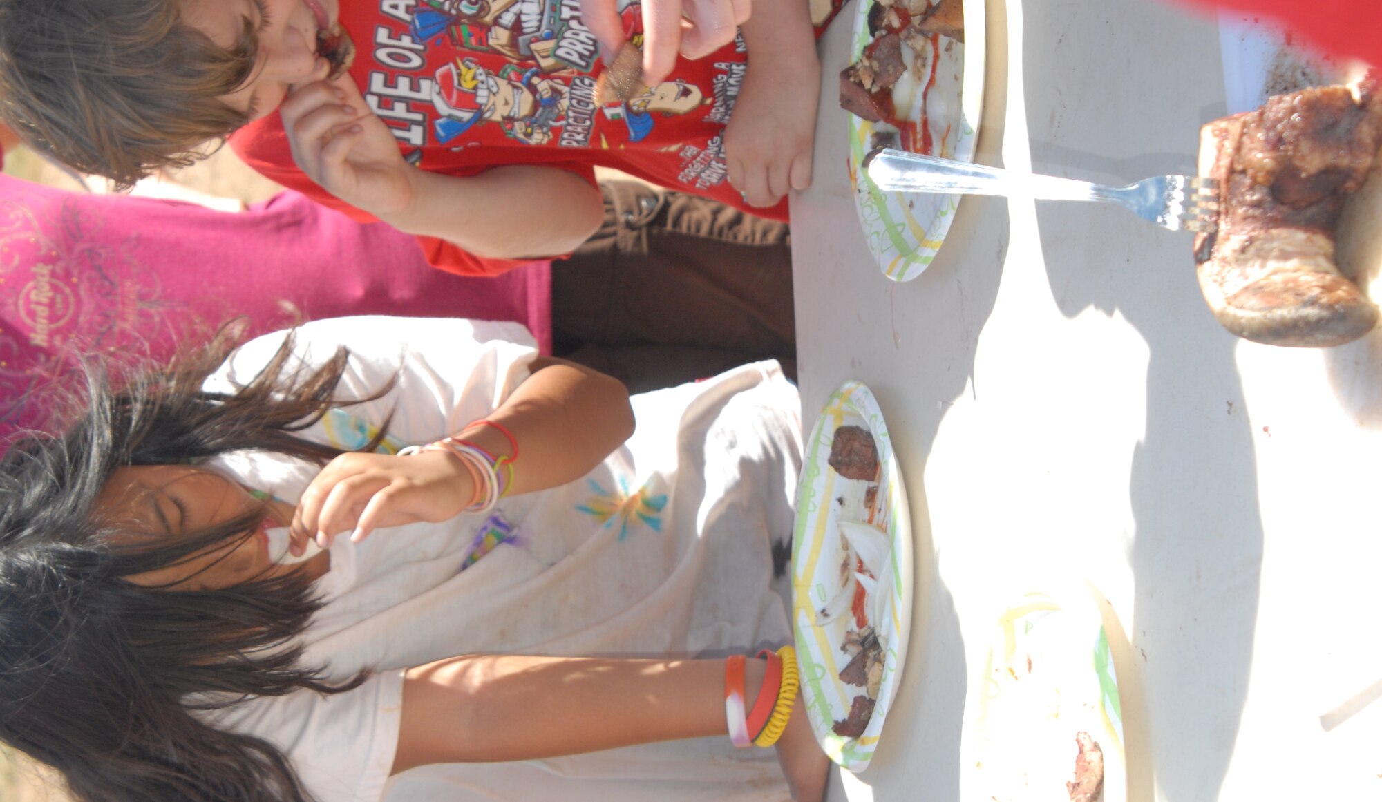Rachel Kang, 11, and Ryan Shocker, 10, try to finish off their plate of Native Cuisine during the Youth Center's 9th Annual Survivor Weekend June 4-6. The menu included cow tongue and liver, raw onions and pickled sardines. Fourteen youth ages 9-18 spent three days at Hot Water Slough Park competing in "Survivor" challenges that tested their strength and taught them problem solving skills, team work and self confidence. (U.S. Air Force photo/Connie Hempel)