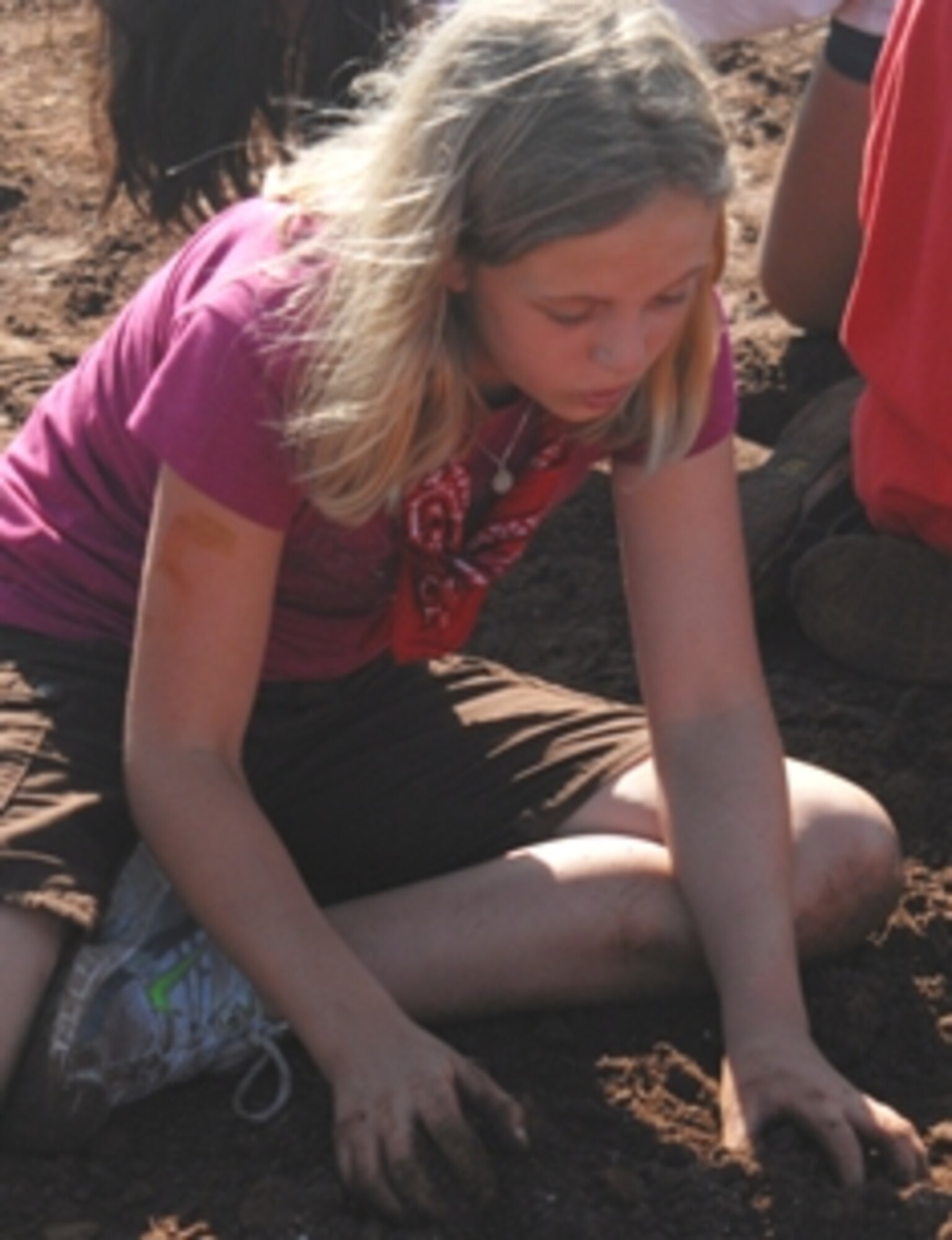Morgan Shuttleworth, 11, digs for padlock keys to unlock her teammates during the Youth Center's 9th Annual Survivor Weekend June 4-6 at Hot Water Slough Park. Fourteen youth ages 9-18 spent three days competing in "Survivor" challenges that tested their strength and taught them problem solving skills, team work and self confidence. (U.S. Air Force photo/Connie Hempel)