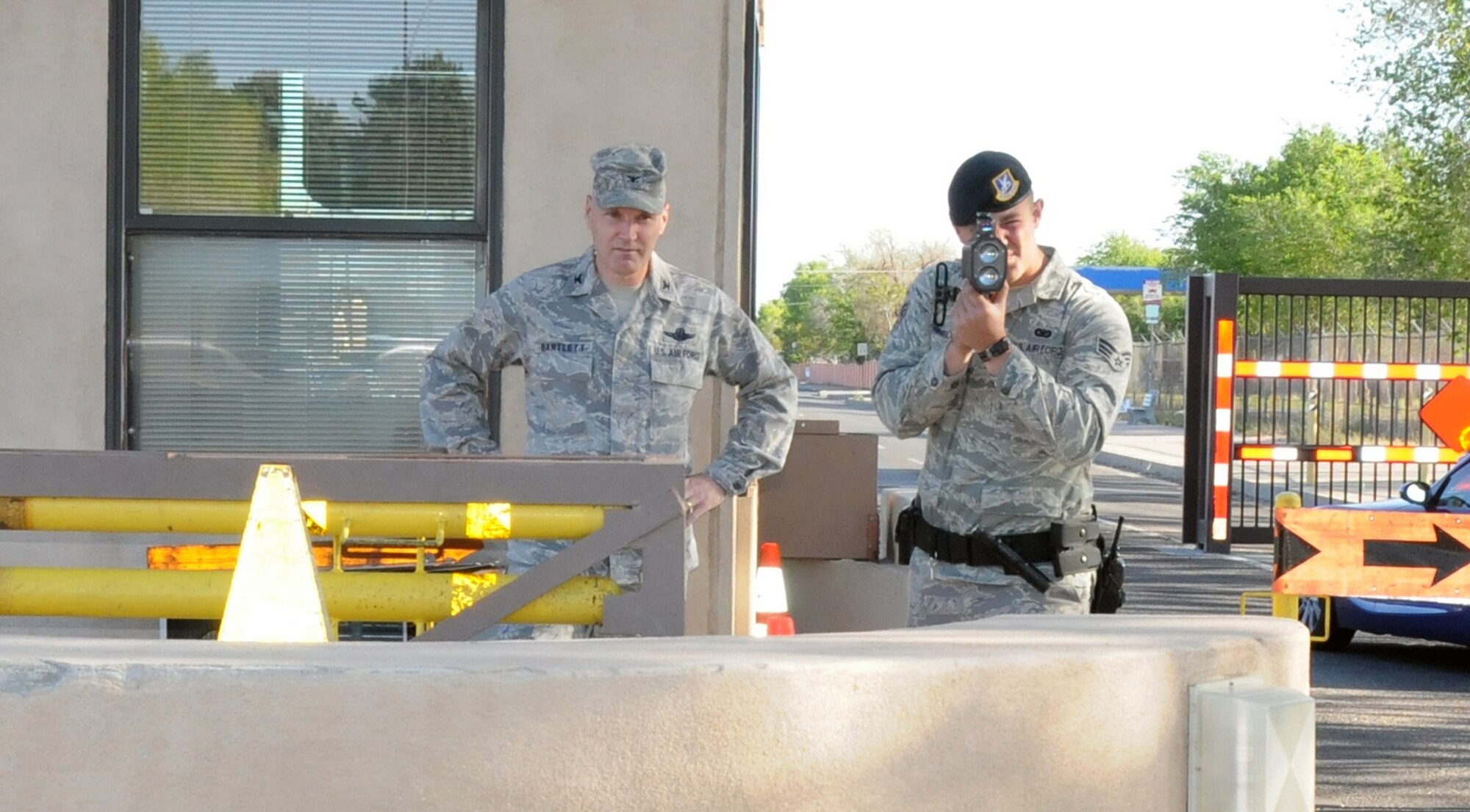 Col. Matthew Bartlett, 377 MSG commander  observes the outbound traffic at the Wyoming Gate while Senior Airman Charlie Cornacchio, 377 SFS  operates the radar gun  checking the 15 mph speed limite of the vehicles departing the base on May 11th. U. S. Air Force photo by Dennis Carlson