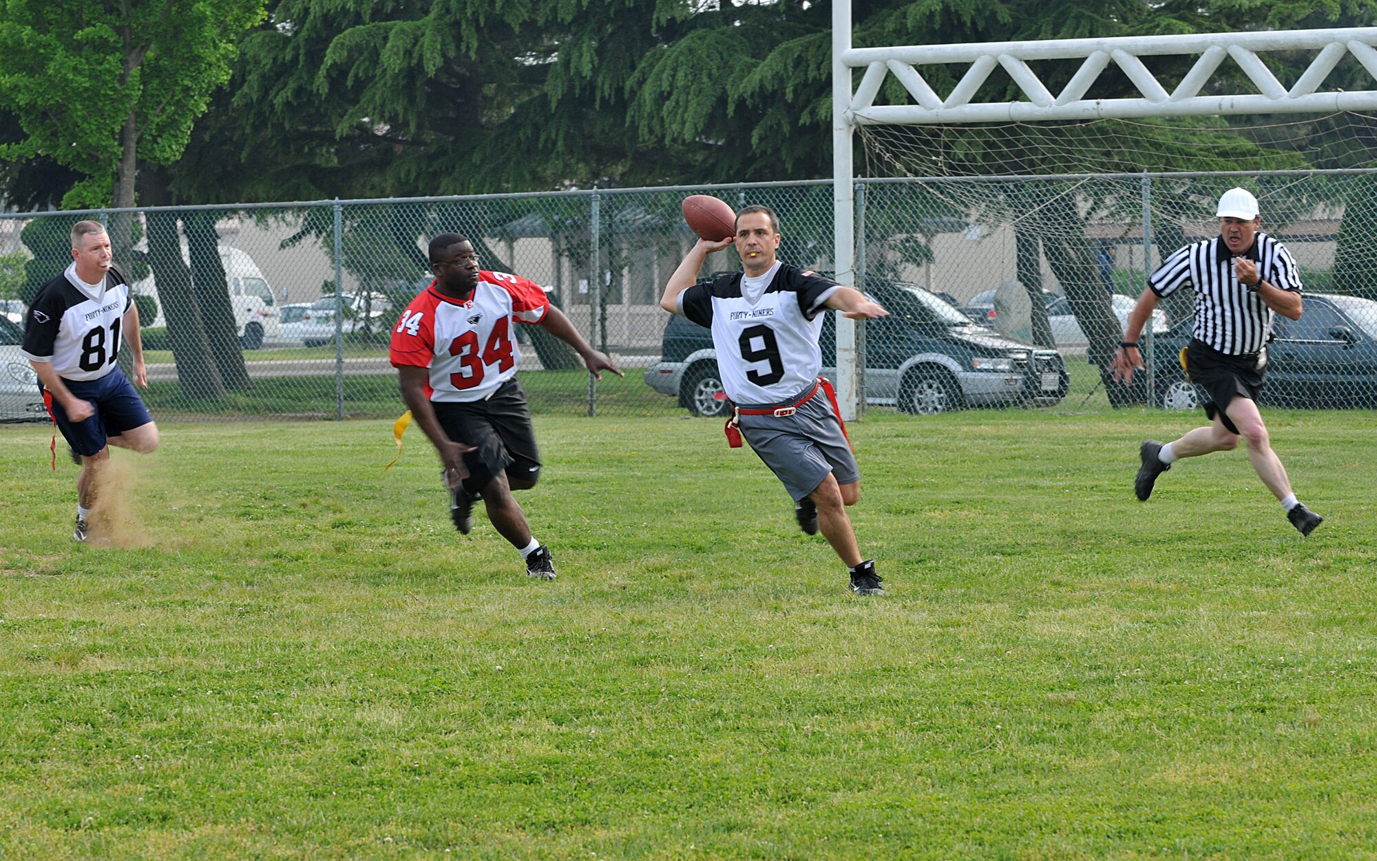 Maj. Peter Gryzen, 8th Maintenance Operations Squadron commander and Eagles quarterback, lines up the pass as Master Sgt. Rafeal Vance, 8th Aircraft Maintenance Squadron, runs in to block during the Chiefs vs. Eagles game May 21 at Kunsan Air Base, Republic of Korea. The Chiefs and Eagles game was a culmination of events that took place throughout the Junior Enlisted Appreciation Day. The JEAD was hosted by members of the Kunsan Top III Association and supported by wing leadership. (U.S. Air Force photo/Capt. Shannon Collins)