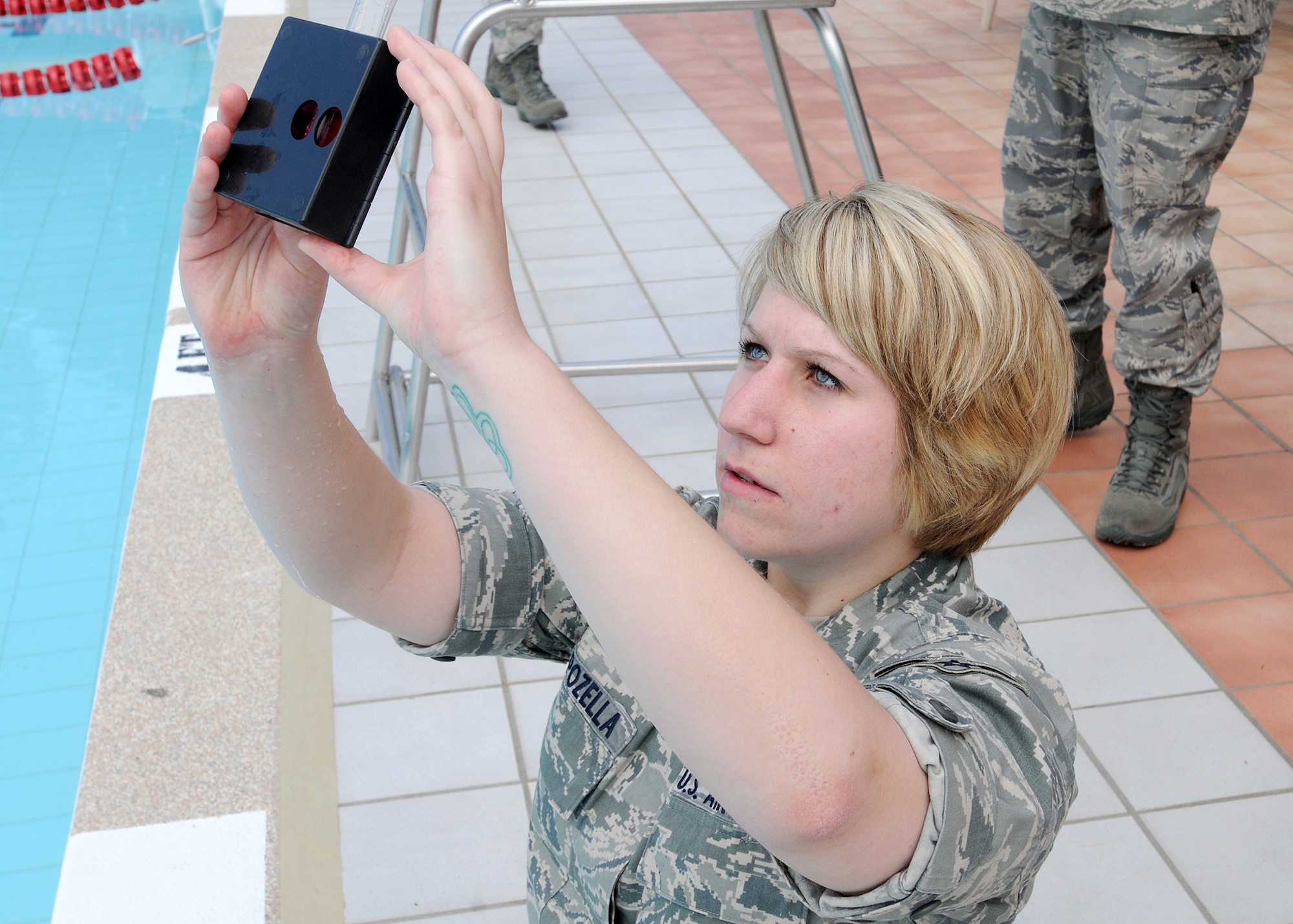 Airman 1st Class Kerry Capozella, 31st Aerospace Medicine Squadron bioenvironmental technician, checks acidity levels in the base pool June 4.  Keeping the correct levels ensures the safety of the Aviano pool users.  (U.S. Air Force photo/Senior Airman Tabitha M. Mans)