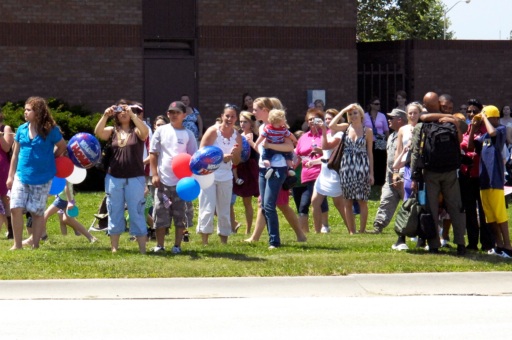 WHITEMAN AIR FORCE BASE, Mo. - Friends and family members gather near flight line road, June 4, to welcome home their loved ones returning from a four-month deployment to Andersen AFB, Guam. More than 200 members of Team Whiteman deployed along with four B-2 Spirits to provide a continuous bomber presence in the Pacific. (U.S. Air Force photo/Senior Airman Jason Barebo)