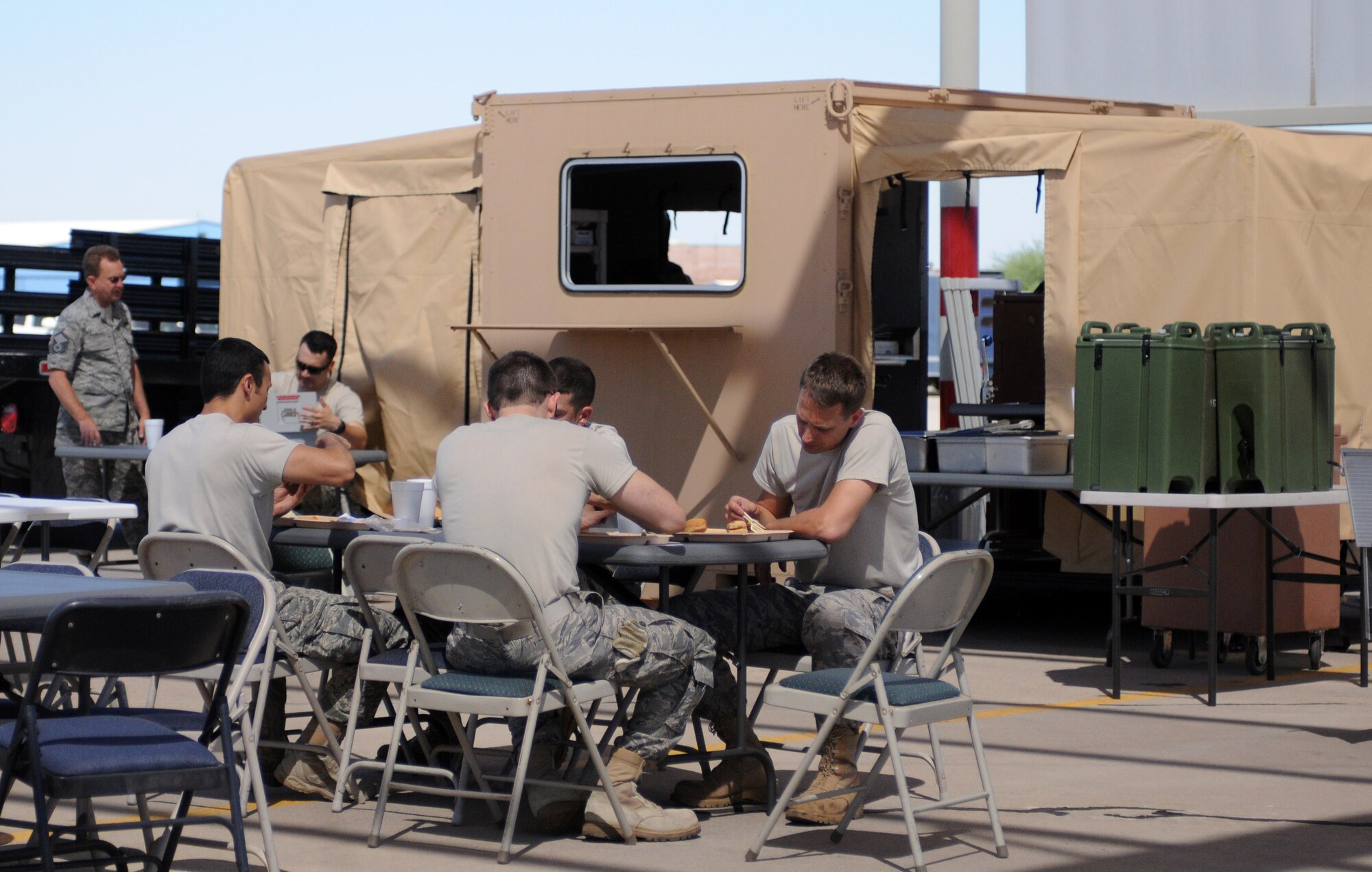 Guardsmen assigned to the 162nd Fighter Wing enjoy a lunch on the flightline at Tucson International Airport, June 5. Members of the 162nd Services Flight practiced using a Single Pallet Expeditionary Kitchen during a drill weekend here. (Air Force photo by Airman First Class Krystal Tomlin)