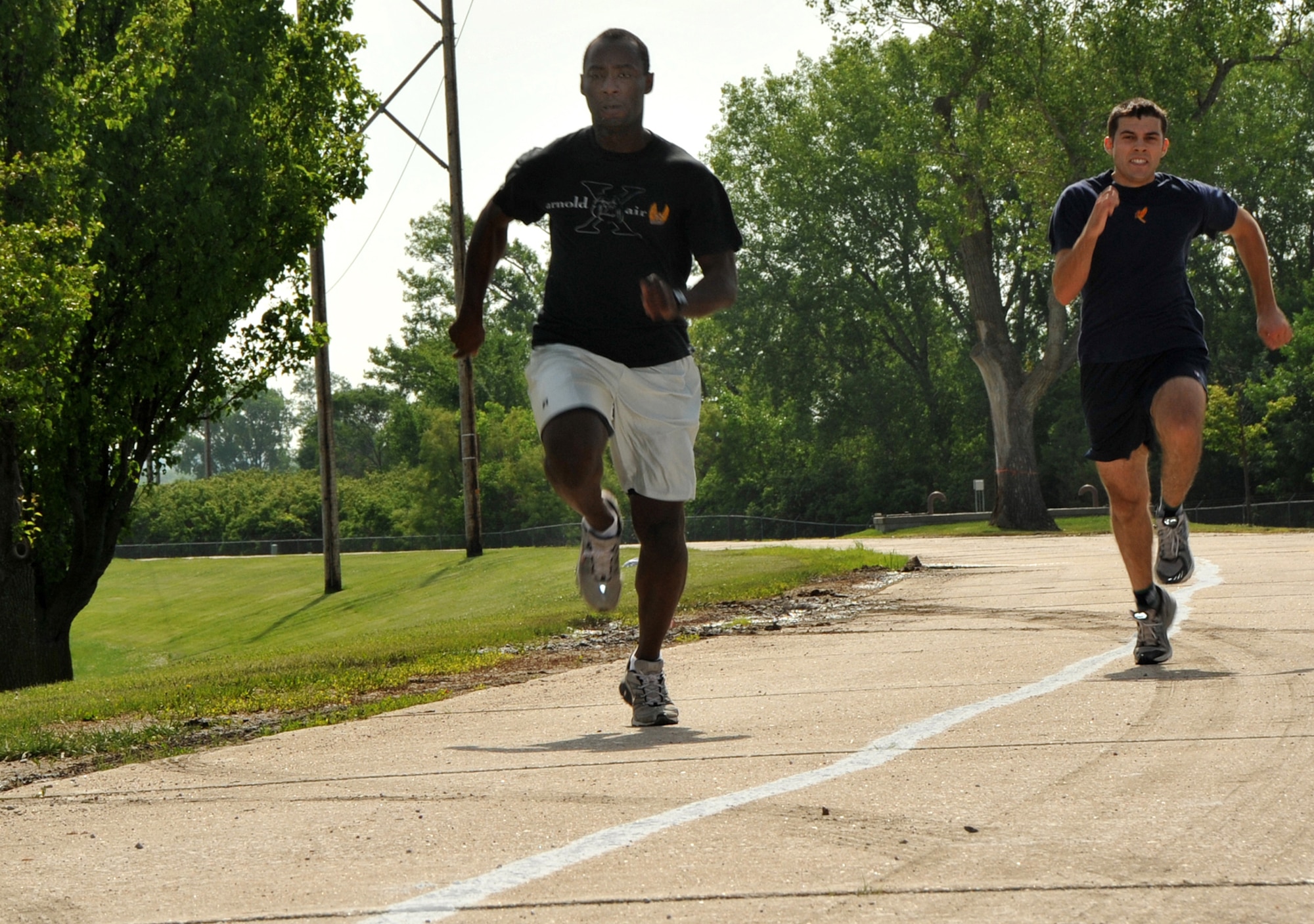 OFFUTT AIR FORCE BASE, Neb. - 1st Lt. David Omolayo from the 338th Combat Training Squadron, pulls ahead of James Butler, a Reserve Officer Training Corps cadet from the University of Nebraska at Omaha, in the 110 yard dash event here during the 55th Wing's annual Sports Day. Sports Day offered many events including  ultimate Frisbee, volleyball, a 5K race and much more. The event is designed to promote good health and increase unit morale. U.S. Air Force Photo by Jeff W. Gates.
