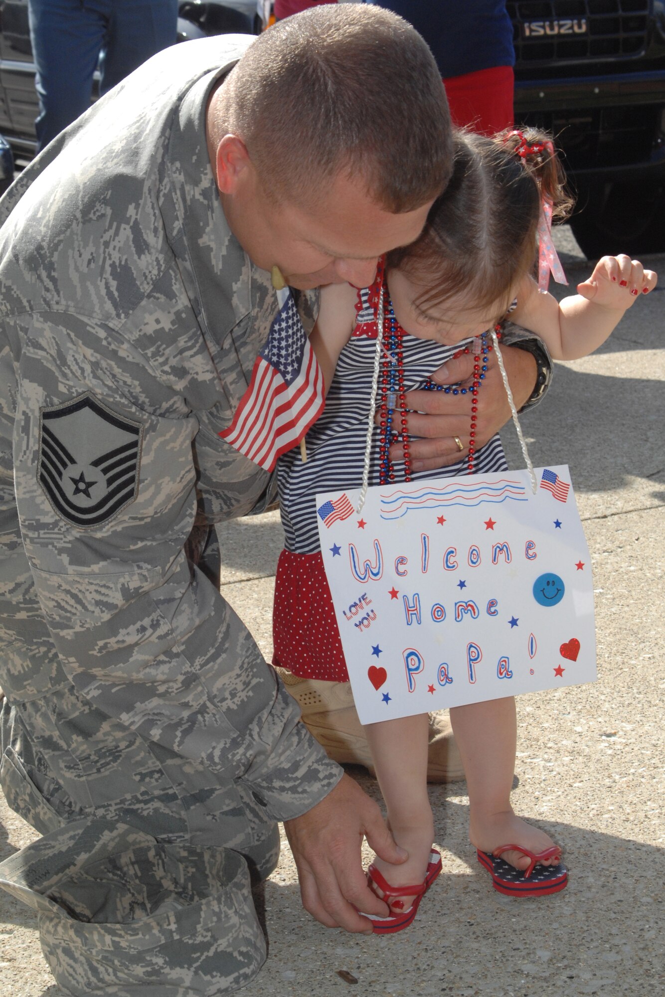 GRISSOM AIR RESERVE BASE, Ind. -- Master Sgt. Christopher Miller, fire team leader with the 434th Security Forces Squadron, is put to work immediately helping his granddaughter Aspen with her flip flops upon his return from a six-month deployment to Iraq. Aspen lost her shoes while greeting her Pa Pa when he arrived back here Monday. Sergeant Miller and other SFS members deployed to Kirkuk, Iraq for six months. (U.S. Air Force photo/Tech. Sgt. Douglas Hays)
