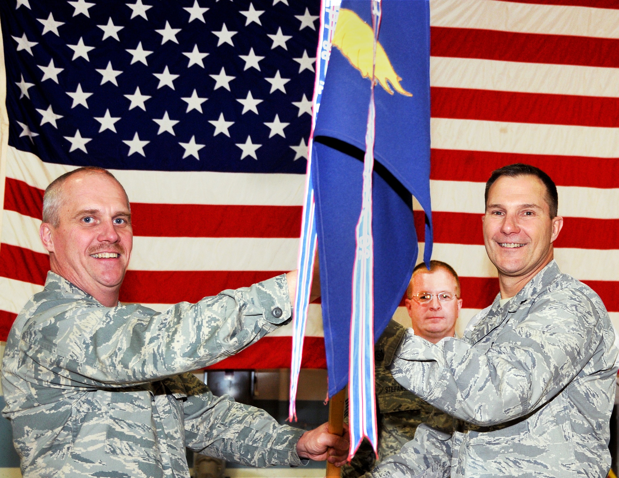 Col. Gary Ebben, Volk Field commander, presents Lt. Col. Jerry Iverson with the official guidon of the 128th Air Control Squadron during a change of command ceremony at Volk Field May 1. Iverson assumed command of the 128th ACS from Lt. Col. Herb Dannenburg.

