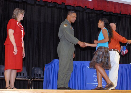 Excited 5th Grader Desireé Flemming shakes the hand of Maj. Gen. Garry C. Dean, 1st Air Force commander, during Tyndall Elementary School’s 5th Grade Recognition Ceremony June 4, 2010 as  Principal Libbie Pippin (left) proudly looks on.