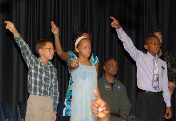 Fifth graders Brandon Oncale, Adora Walker, Ashley Kennedy and Diy’Quon Roulhac sing the Tyndall Thunderbird song during the school’s 5th Grade Recognition Ceremony June 4, 2010, where Maj. Gen. Garry C. Dean (pictured rear) delivered the ceremony’s keynote speech.  “Continue to strive for excellence and take advantage of every opportunity,” General Dean told the students.