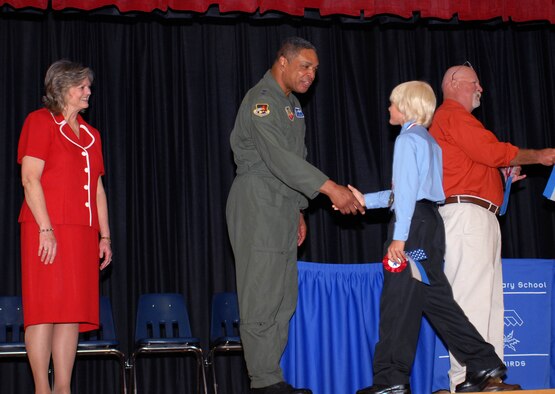 Maj. Gen. Garry C. Dean, 1st Air Force commander, shakes Tyndall Elementary School 5th Grader Cody George’s hand as Principal Libbie Pippin looks on during the school’s 5th Grade Recognition Ceremony June 4, 2010.