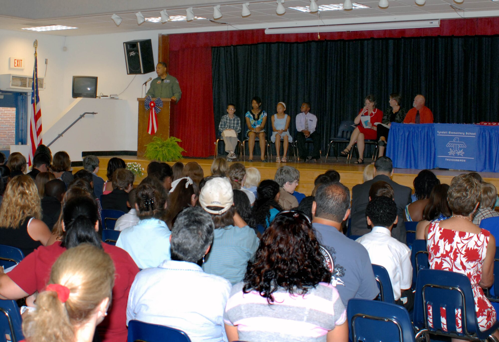 Maj. Gen. Garry C. Dean, 1st Air Force commander, delivers his presentation to Tyndall Elementary School 5th Graders at their Recognition Ceremony as proud family members and friends fill the school’s cafetorium June 4, 2010.  Pictured on stage (l to r) are Brandon Oncale, Adora Walker, Ashley Kennedy, Diy’Quon Roulhac, Principal Libbie Pippin, Vice Principal Susan Ross, and guidance counselor David Steckel.