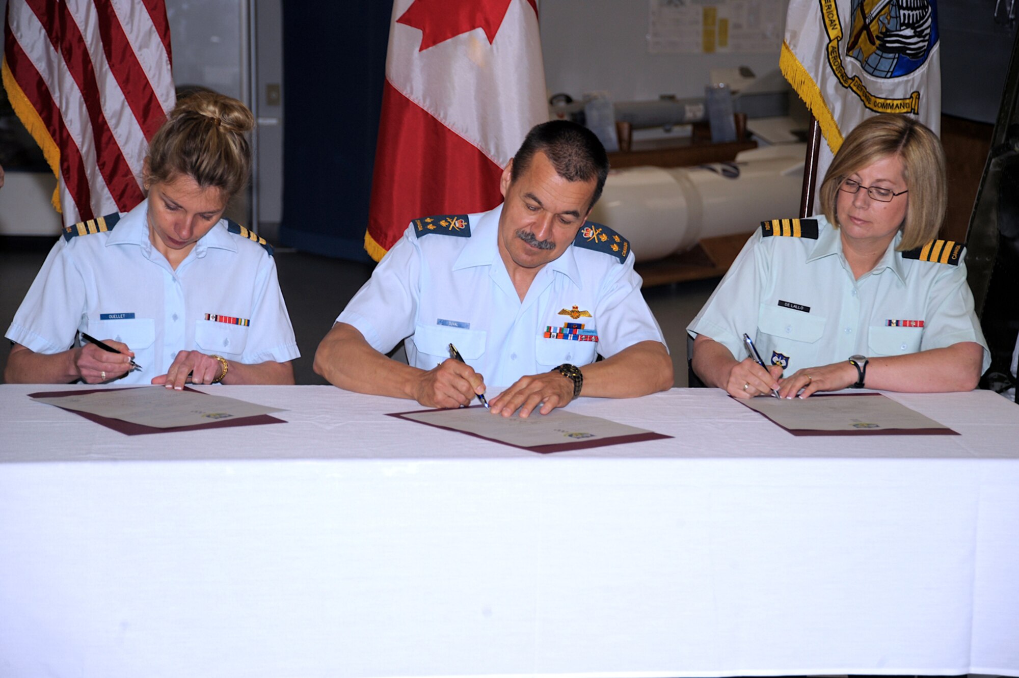 PETERSON AIR FORCE BASE, Colo. -- The Canadian Forces Support Unit had a change of command June 3 at the Peterson Air and Space Museum. Canadian Air Force Lt. Col. Nancy Ouellet (left), outgoing commander, signed over command to Canadian Army Lt. Col. Beverley De Lallo (right), gaining commander. Canadian Lt. Gen. J.M. Duval, NORAD deputy commander, presided. The Canadian Forces Support Unit has about 150 personnel assigned, and is one of the 21st Space Wing’s many mission partners. (U.S. Air Force photo/Tech. Sgt. Aaron Bujan)
