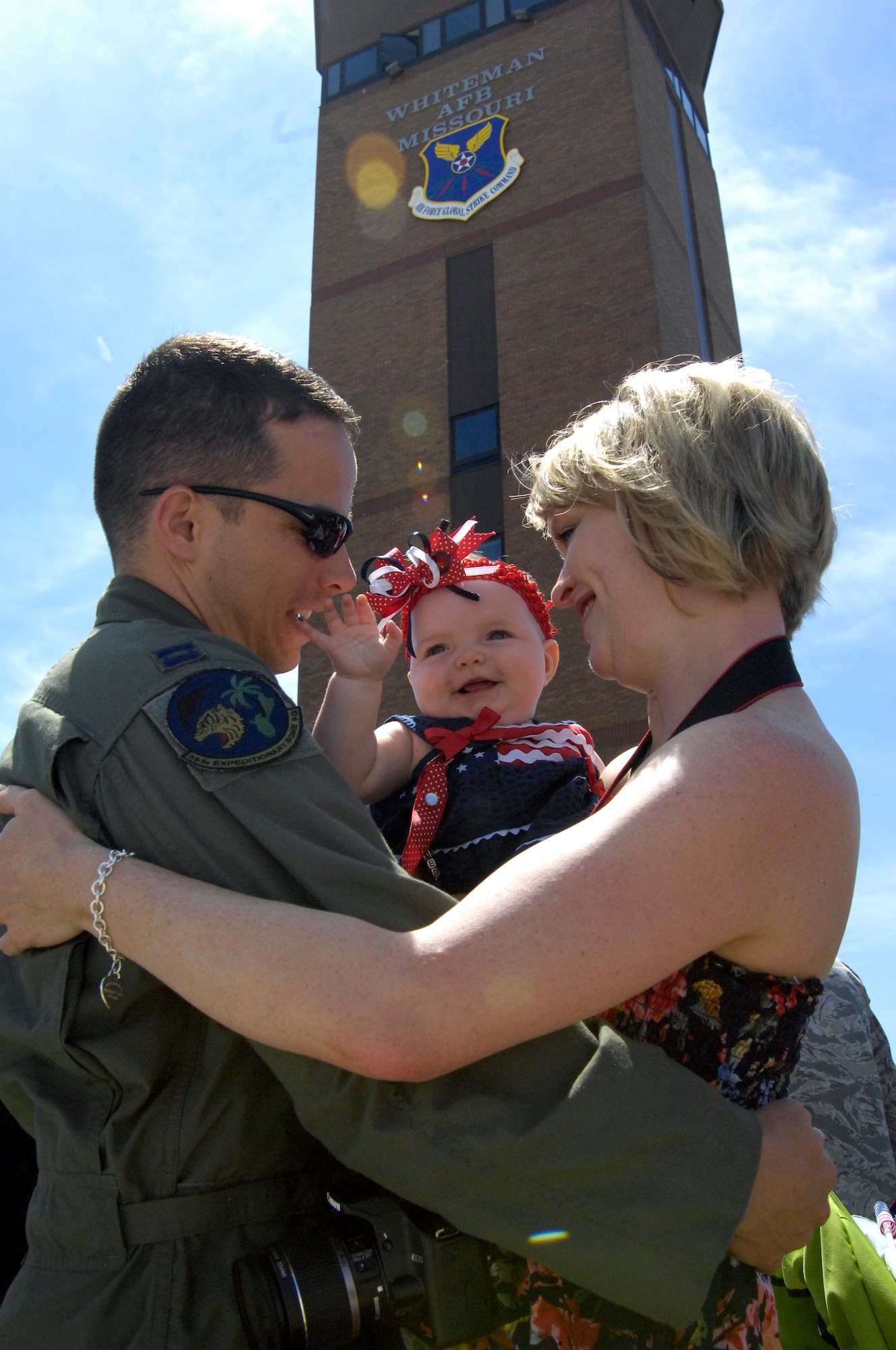 WHITEMAN AIR FORCE BASE, Mo. - Capt. Brian Palmer, 393rd Bomb Squadron, embraces his wife, Michelle, and 7-month-old daughter, Dulaney, June 4 upon returning from a four-month deployment to Andersen Air Force Base, Guam. More than 200 Airmen deployed in support of the B-2 Spirit's continuing bomber presence in the Pacific. (U.S. Air Force photo/Senior Airman Jason Barebo)