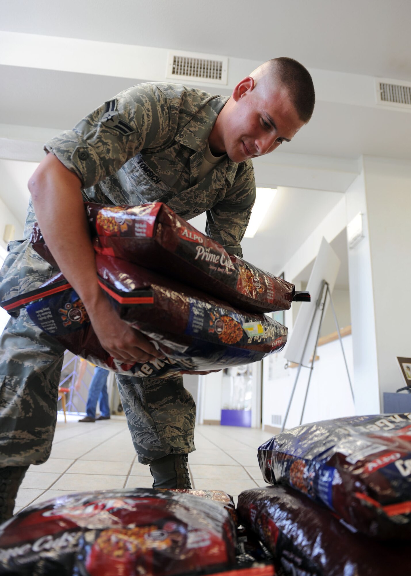 ABILENE, Texas-- Airman 1st Class John Tomsich, 7th Operations Support Squadron air traffic controller, stacks bags of dog food at the Rescue the Animals, SPCA shelter June 7 here. Dyess Airmen had a dog food drive and accumulated roughly 3000 pounds of dog food they donated to the Rescue the Animals, SPCA shelter. They raised enough food to feed the animals for 10 weeks. It is the only shelter nearby that does not euthanize. (U.S. Air Force photo/Airman 1st Class Brittney Smolinski)