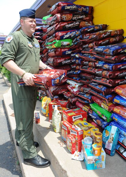 ABILENE, Texas-- 1st Lt.  Paul Cummings, 7th Operations Support Squadron air traffic control liaison, stacks bags of dog food at the Rescue the Animals, SPCA shelter June 7 here. Dyess Airmen had a dog food drive and accumulated roughly 3,000 pounds of dog food they donated to the Rescue the Animals, SPCA shelter. They raised enough food to feed the animals for 10 weeks. It is the only shelter nearby that does not euthanize. (U.S. Air Force photo/Airman 1st Class Brittney Smolinski)
