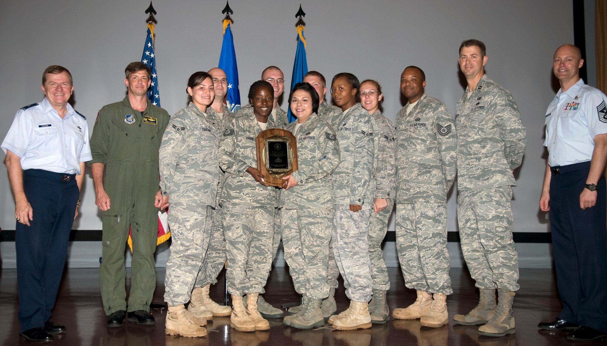 ANDERSEN AIR FORCE BASE, Guam - Brig. Gen. Phil Ruhlman, 36th Wing commander, and Chief Master Sgt. Allen Mullinex, 36th Wing command chief master sergeant, present the 36th Operations Support Squadron's airfield management flight with the Ronald D. McCarthy Airfield Management Facility of the Year award during the monthly wing promotion and recognition ceremony held at the base theater May 27. In 2009, airfield management played an instrumental role in the development of an $8 billion ramp design, providing valuable information to engineers to create a ramp that meets the needs of Marines and Air Force. (U.S. Air Force photo by Airman 1st Class Julian North)