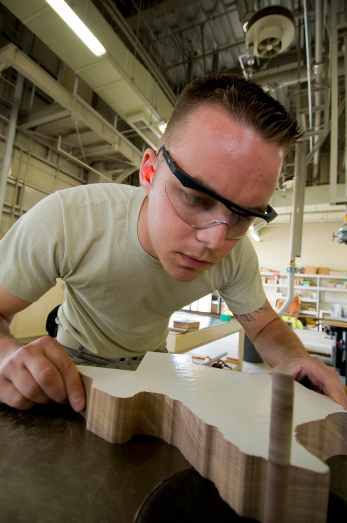 MISAWA AIR BASE, Japan -- Airman 1st Class Daniel Brown, a 35th Civil Engineer Structures Flight structural apprentice and Kilgore, Texas native, sands a block of wood in the shape of Texas, June 3, in preparation for the 22 annual American Day. The 35th CES structures shop prepared country-western cutouts, photo booths and props and built a flatbed trailer stage for the community event.  (U.S. Air Force photo/Senior Airman Jessica Lockoski)