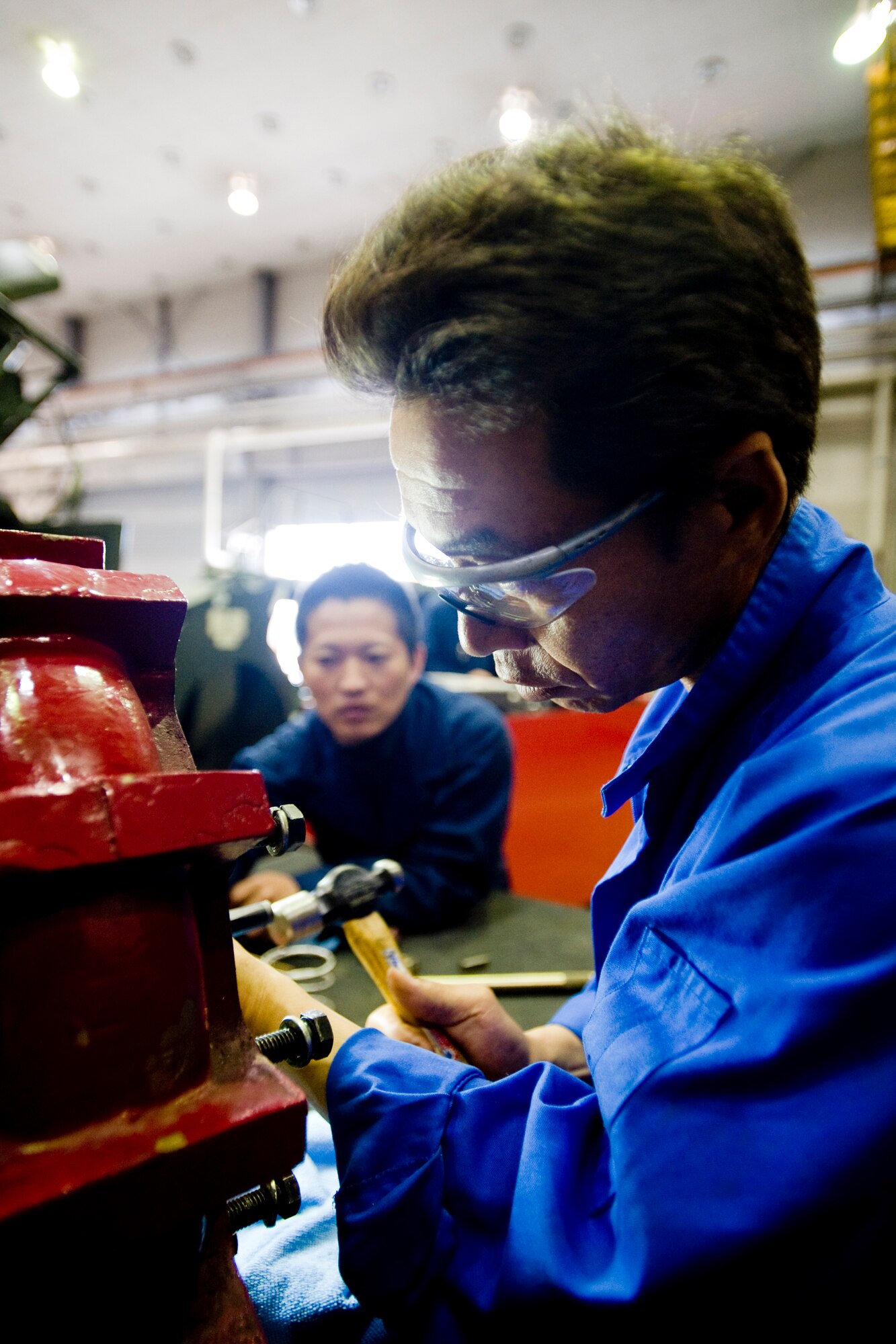 MISAWA AIR BASE, Japan -- Hiromi Orikasa, with assistance from Yonezawa Kunihiro, replaces a fire truck's water-pump seal at the 35th Logistics Readiness Squadron vehicle maintenance shop June 8. The vehicle maintenance shop is responsible for inspecting, repairing, modifying and accounting for all government-owned vehicles on base. (U.S. Air Force photo/Senior Airman Jamal D. Sutter)