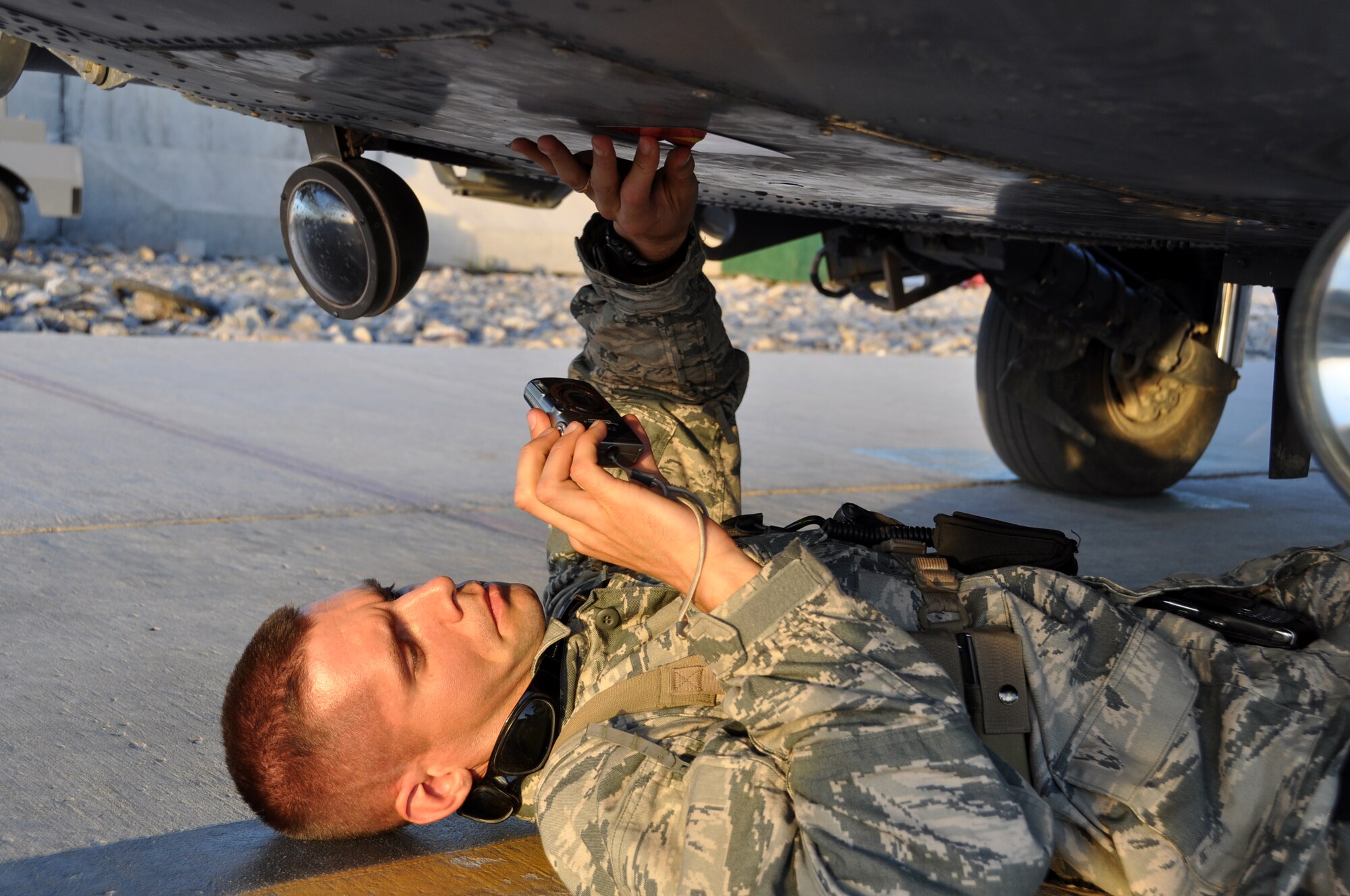Capt. Mark Friesen, assigned to the Joint Combat Assessment Team at Kandahar Airfield, uses a JCAT square to measure the entry point of a bullet on an HH-60G Pave Hawk helicopter that received enemy small arms fire during a rescue mission. Captain Friesen is deployed from Wright-Patterson Air Force Base, Ohio. (U.S Air Force photo by Tech. Sgt. Renni Thornton)
