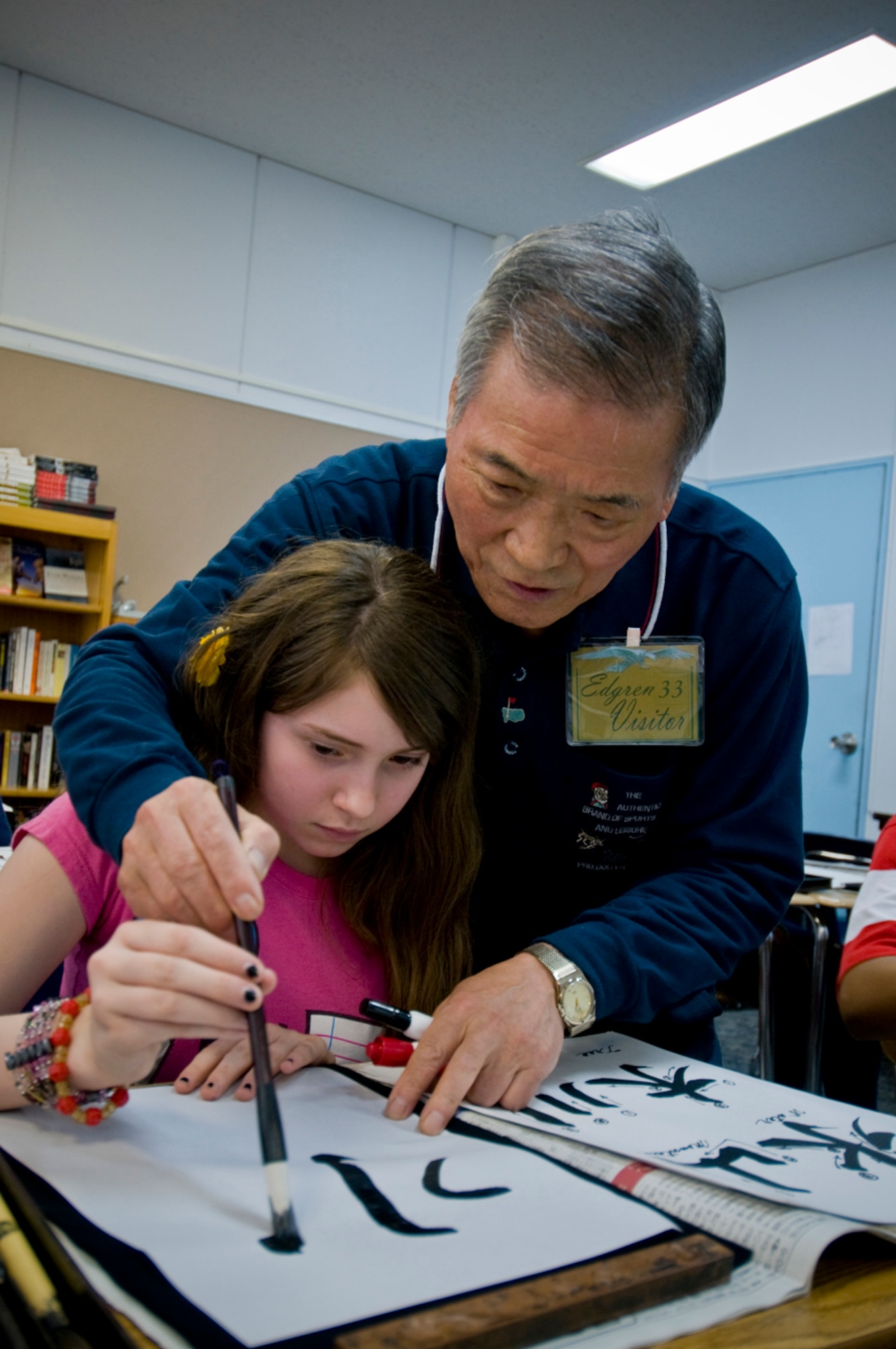 Sensei Koki Takahachi teaches Amber Tetreault, daughter of Master Sgt. Kevin Trereault, proper stroke order and brush movements while writing a Japanese character during a shodo calligraphy lesson at an Edgren High School Intercultural Education class June 3. Mr. Takahachi, who offers Japanese calligraphy classes at the Mokuteki Community Center, visited Edgren’s students to share the art of shodo, a Japanese word that translates to “the way of writing.” (U.S Air Force photo/ Senior Airman Jessica Lockoski)