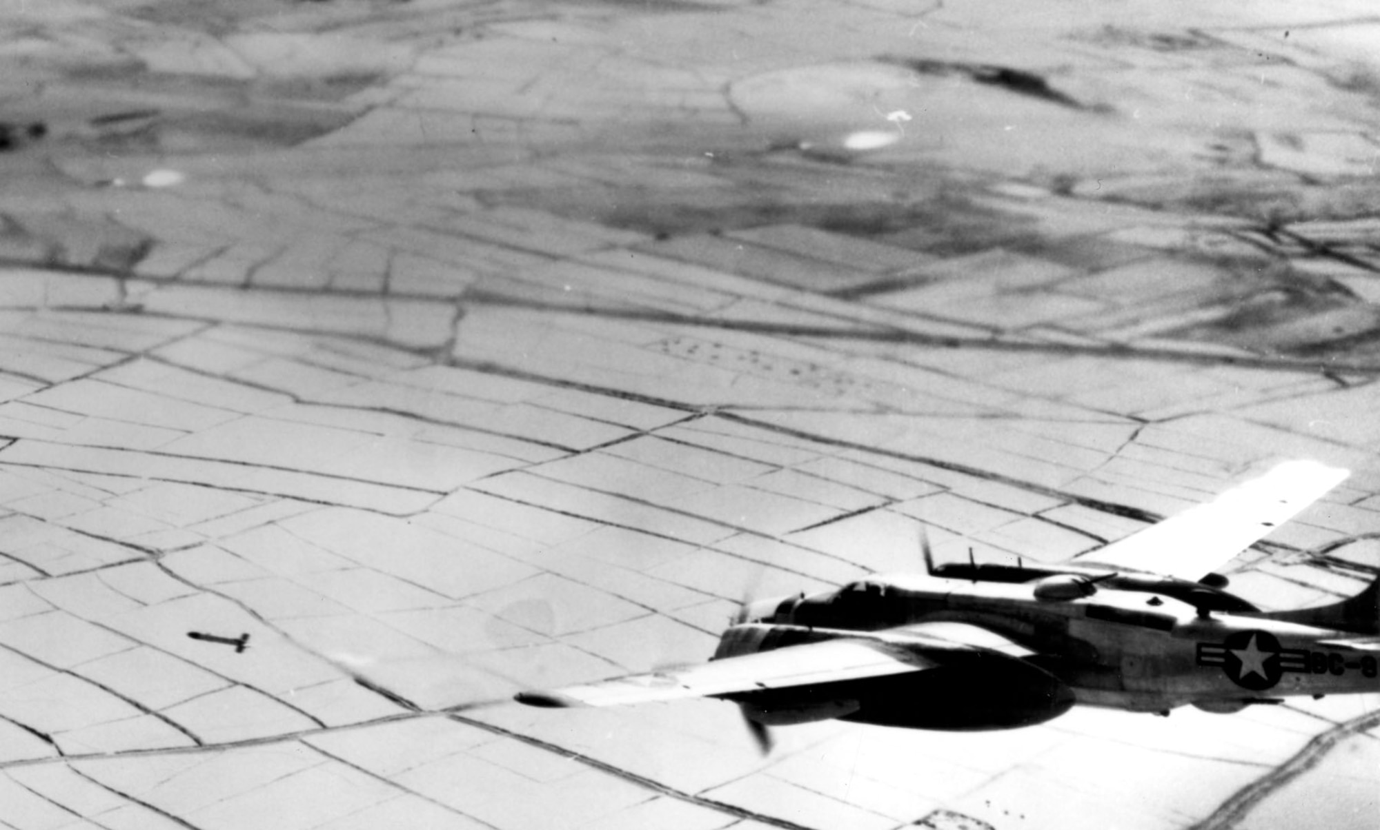 B-26 on an attack run fires one of its 5-inch rockets. In the top part of the photo are two rockets fired from another B-26. (U.S. Air Force photo)