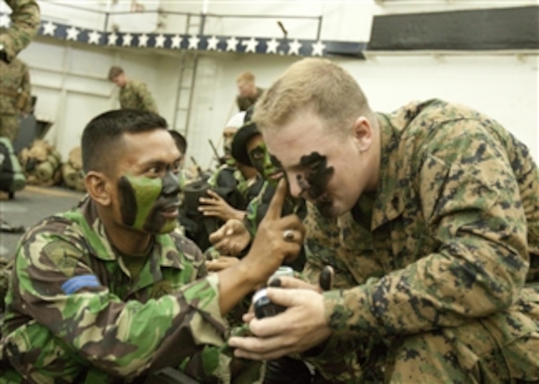 U.S. Marine Corps Sgt. Robert J. Janson, commander of 2nd Platoon, Alpha Company, 2nd Battalion, 24th Marine Regiment, has his face painted camouflage by an Indonesian marine just before loading onto a U.S. Marine Corps amphibious assault vehicle for the amphibious landing phase of Naval Engagement Activity Indonesia 2010 in the Java Sea on May 29, 2010.  